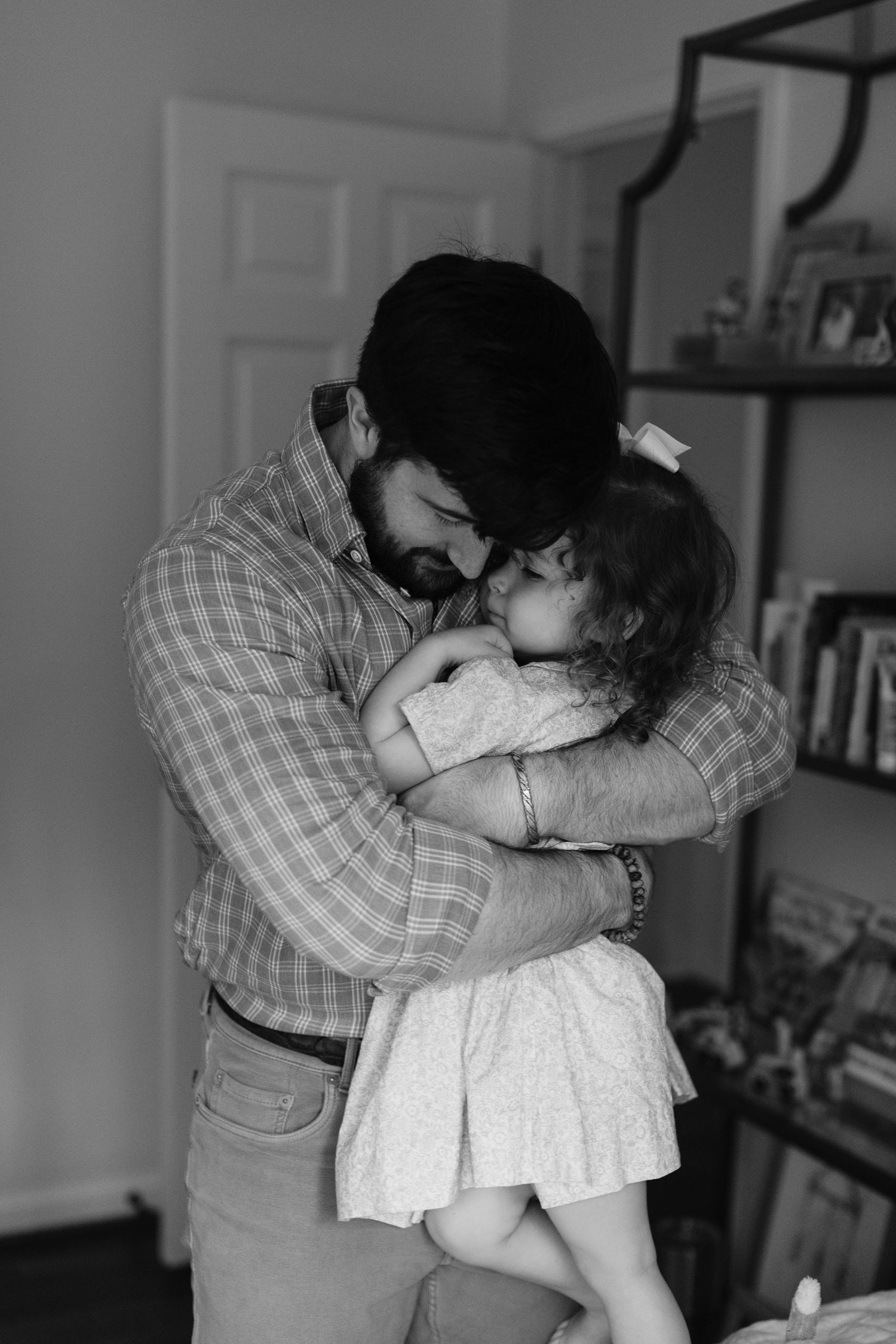 A series of black and white photos showing an intimate embrace between two people in casual attire.