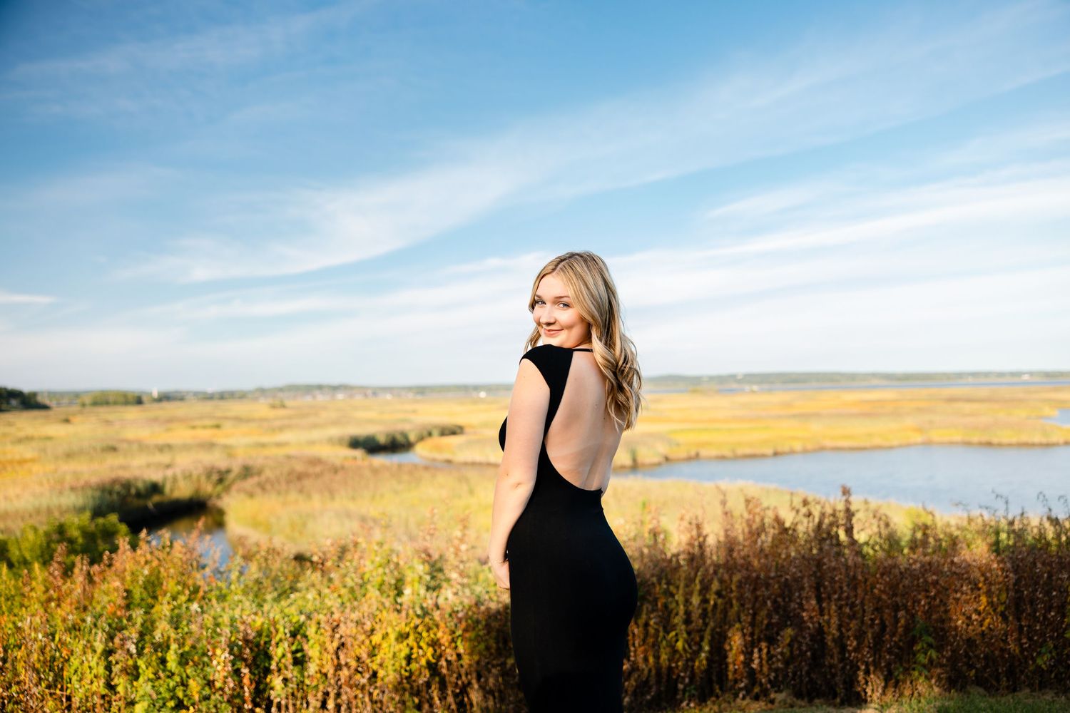Scenic prairie landscape with tall grass and blue sky stretching to horizon.