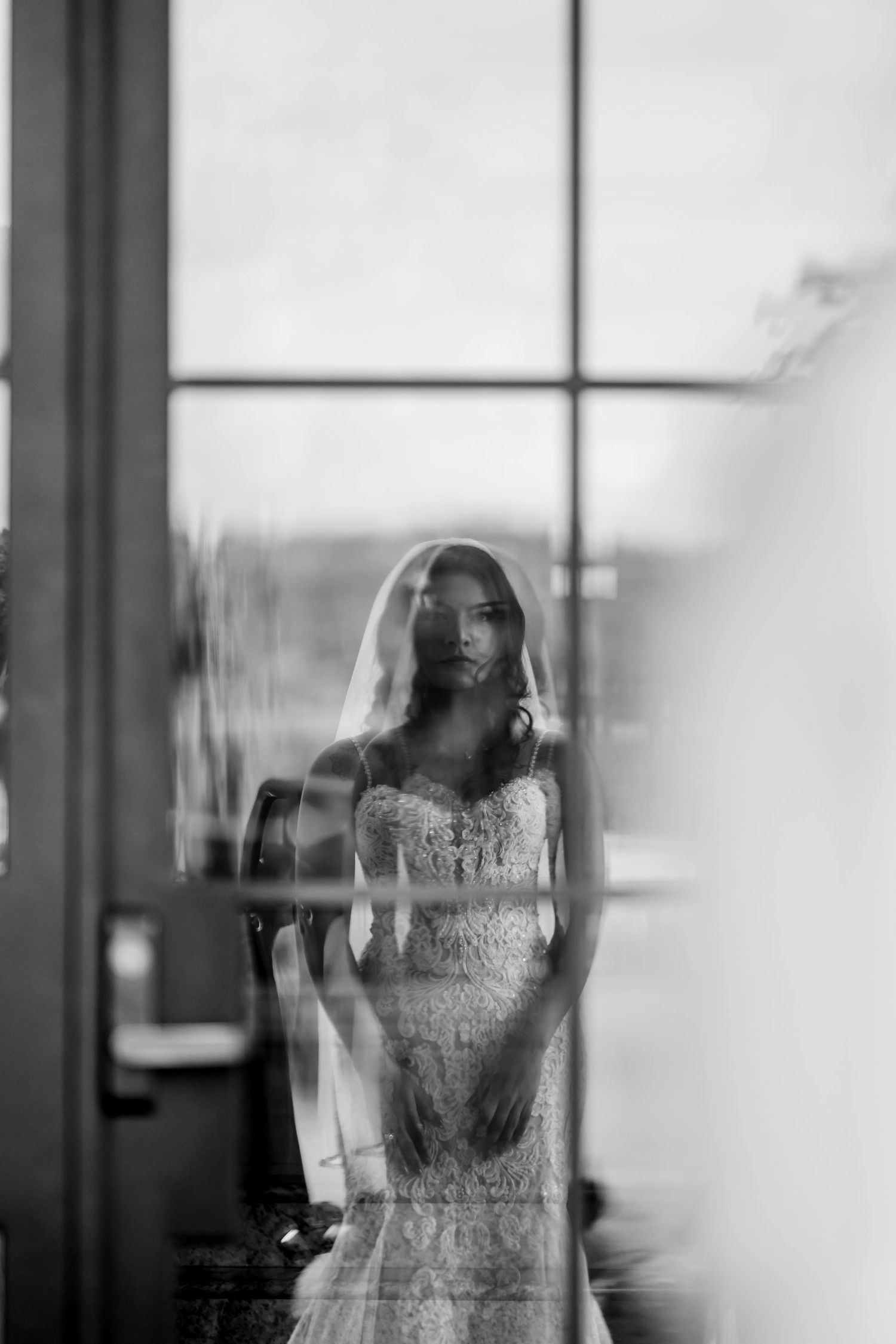 Ethereal black and white photo showing blurred silhouettes through glass.