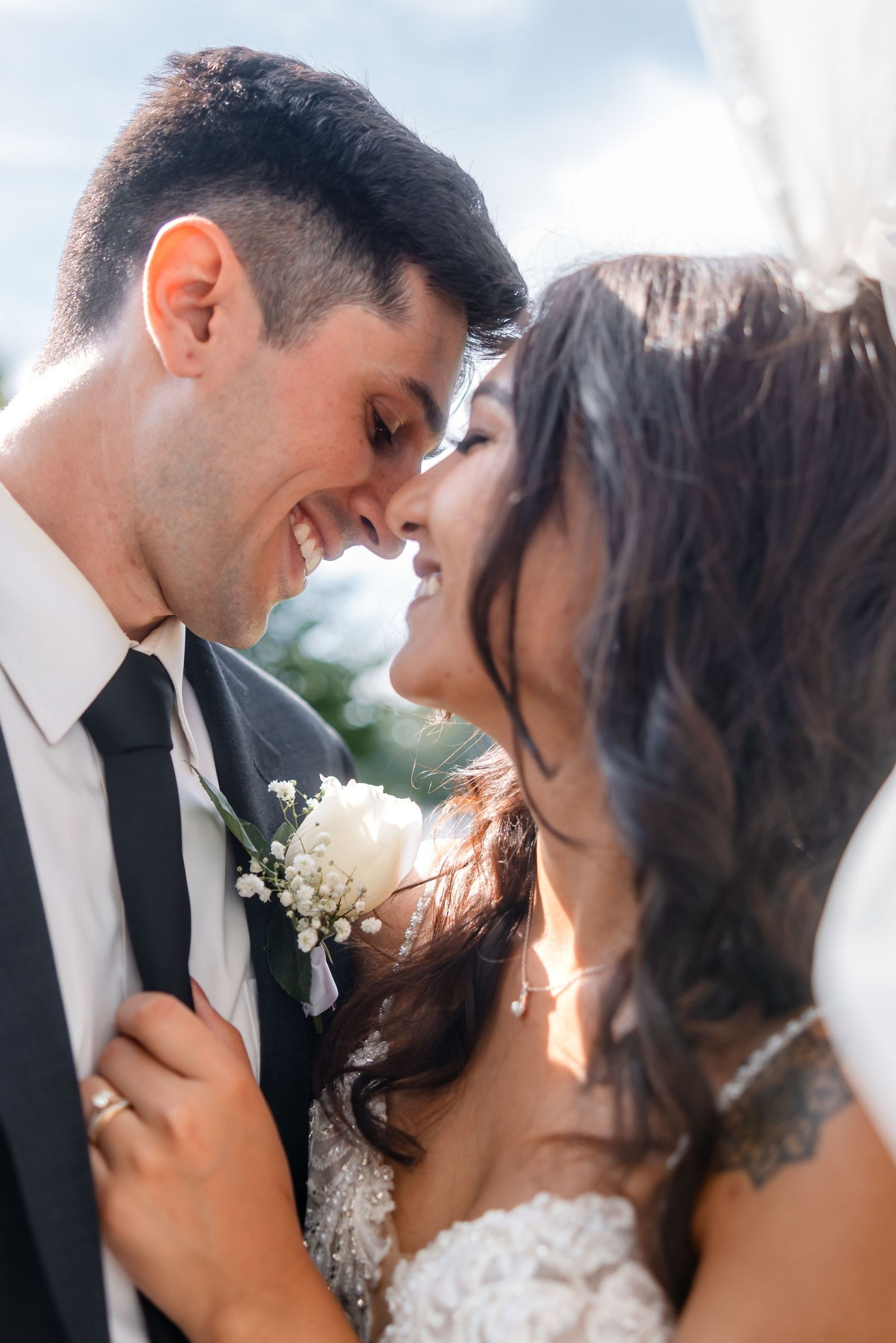 Intimate wedding portraits capturing tender moments between newlyweds in natural sunlight.