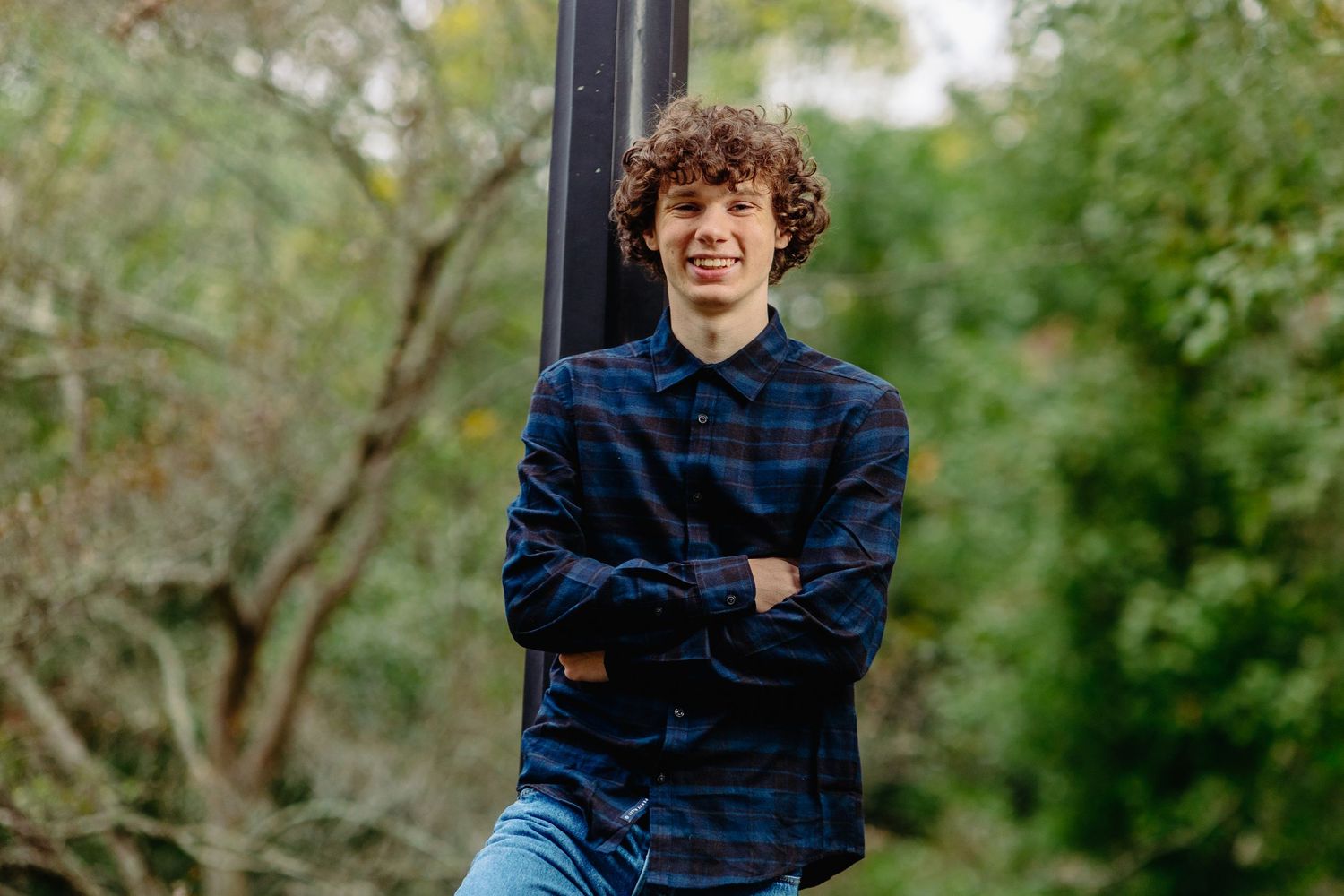 Portrait session against green foliage background on a sunny day.