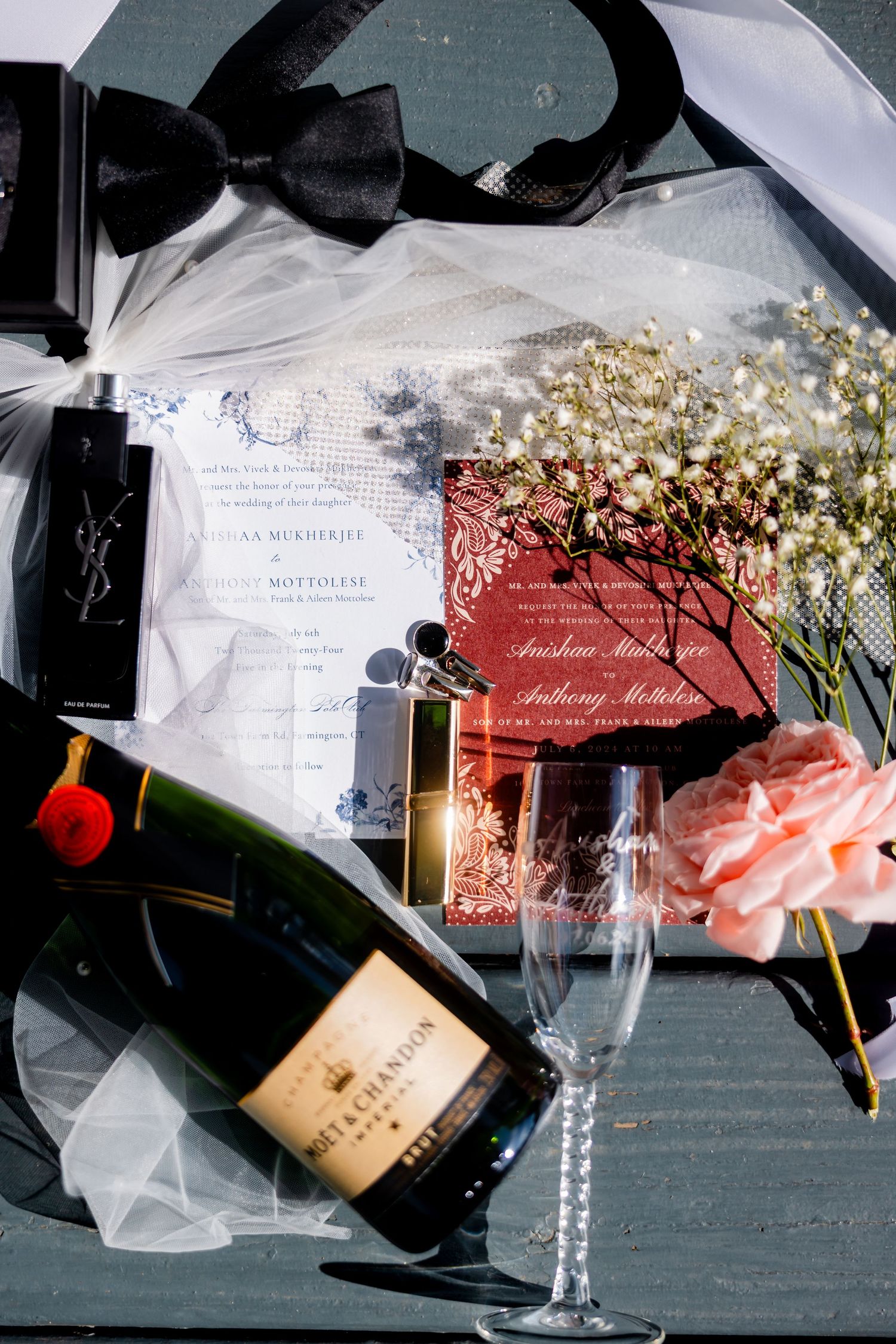 Wedding details including invitations, champagne bottles, and baby's breath flowers arranged artistically.