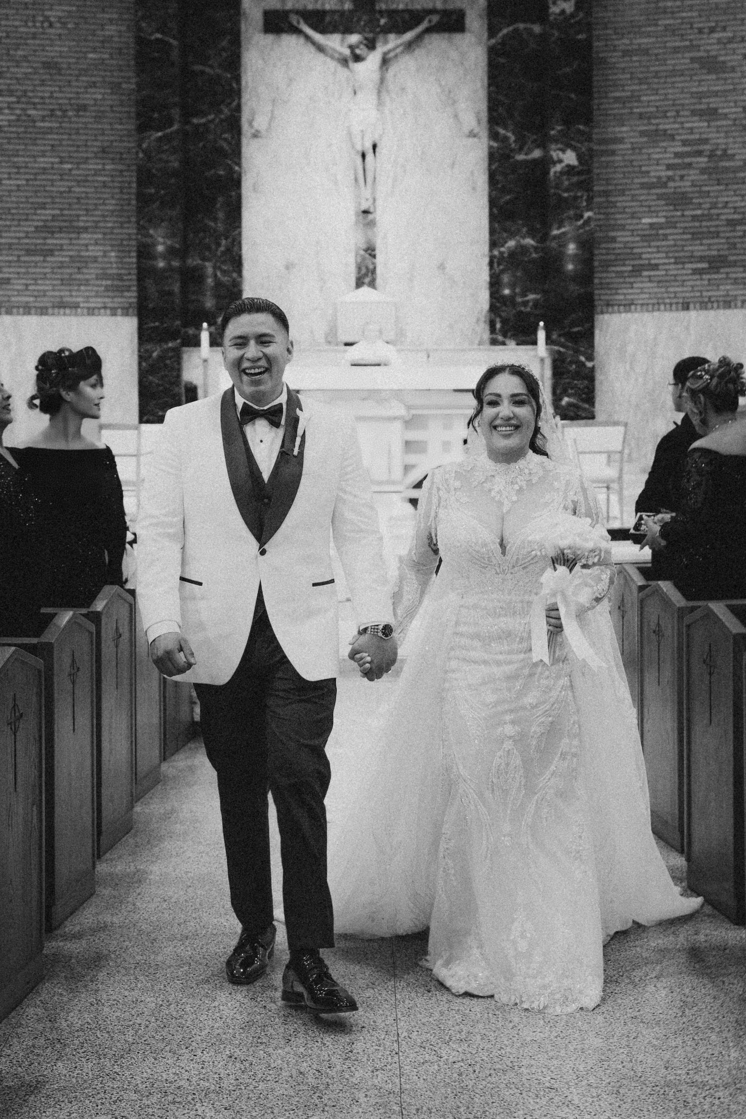 Bride and Groom walking down the aisle of a church in black and white