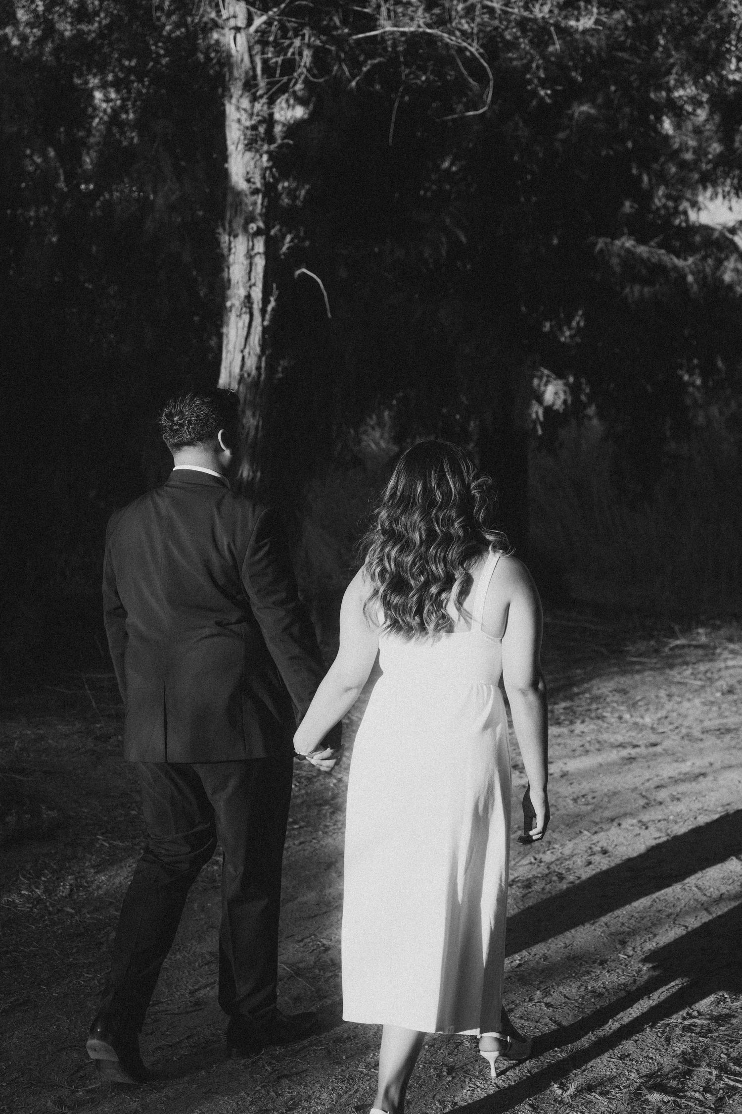 Couple walking along tree-lined path in Yorba Linda engagement shoot
