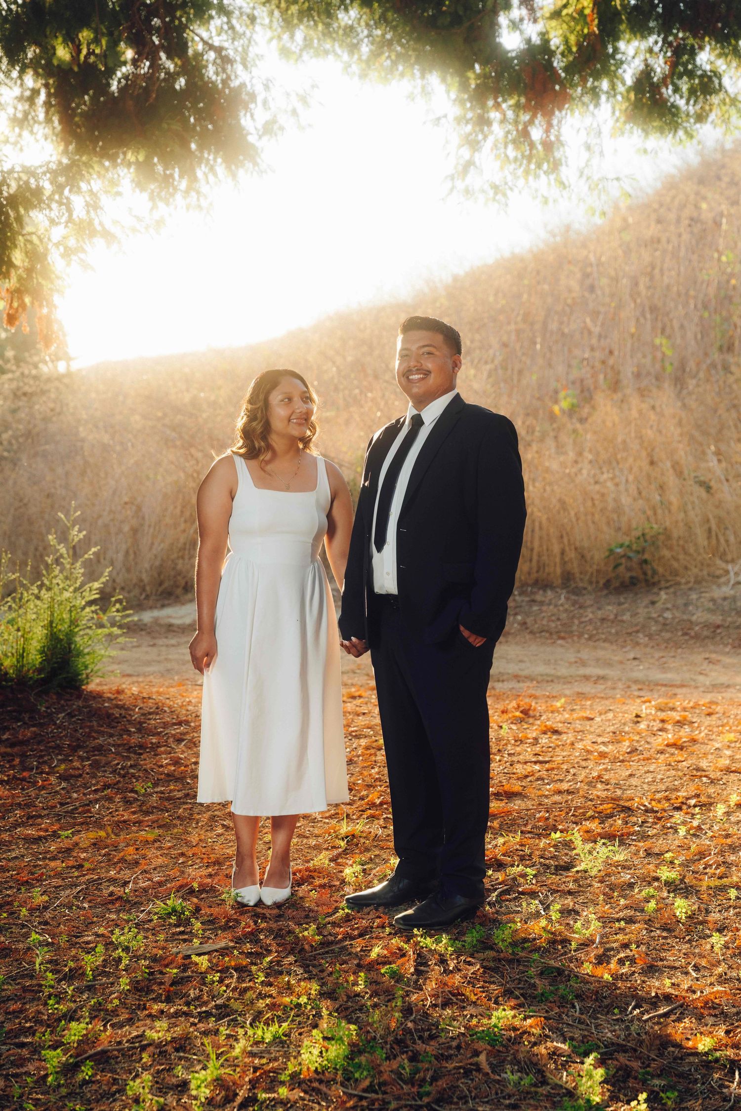 Engaged couple posing with natural light in Orange County garden