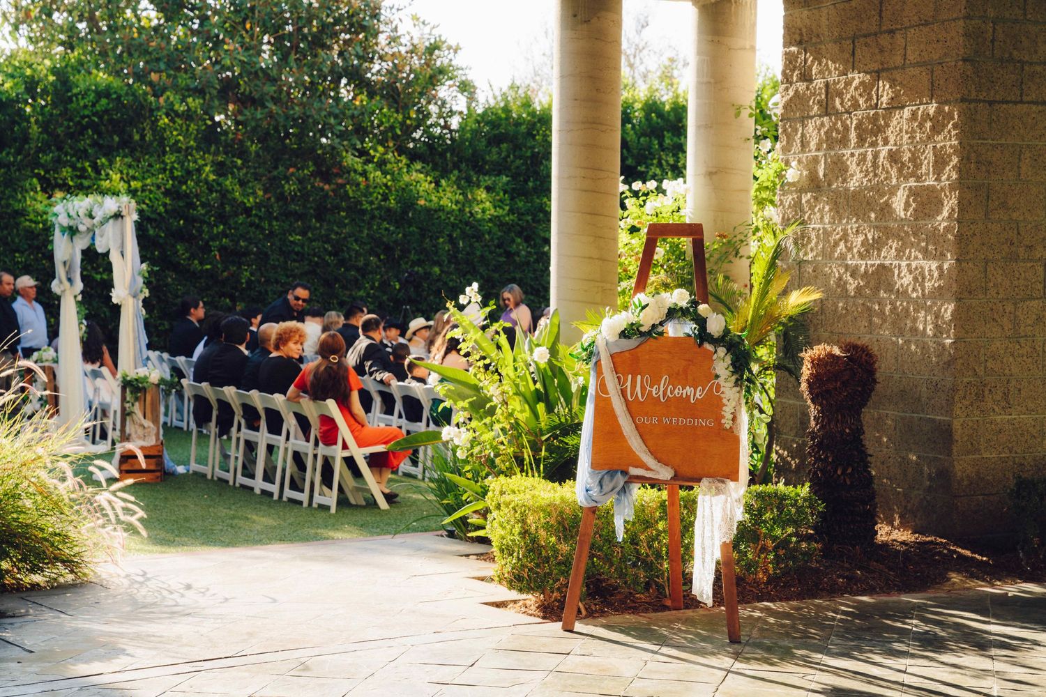 wedding sign showing what event is going on while in the background you see guest sitting down for the wedding at the double tree rosemead