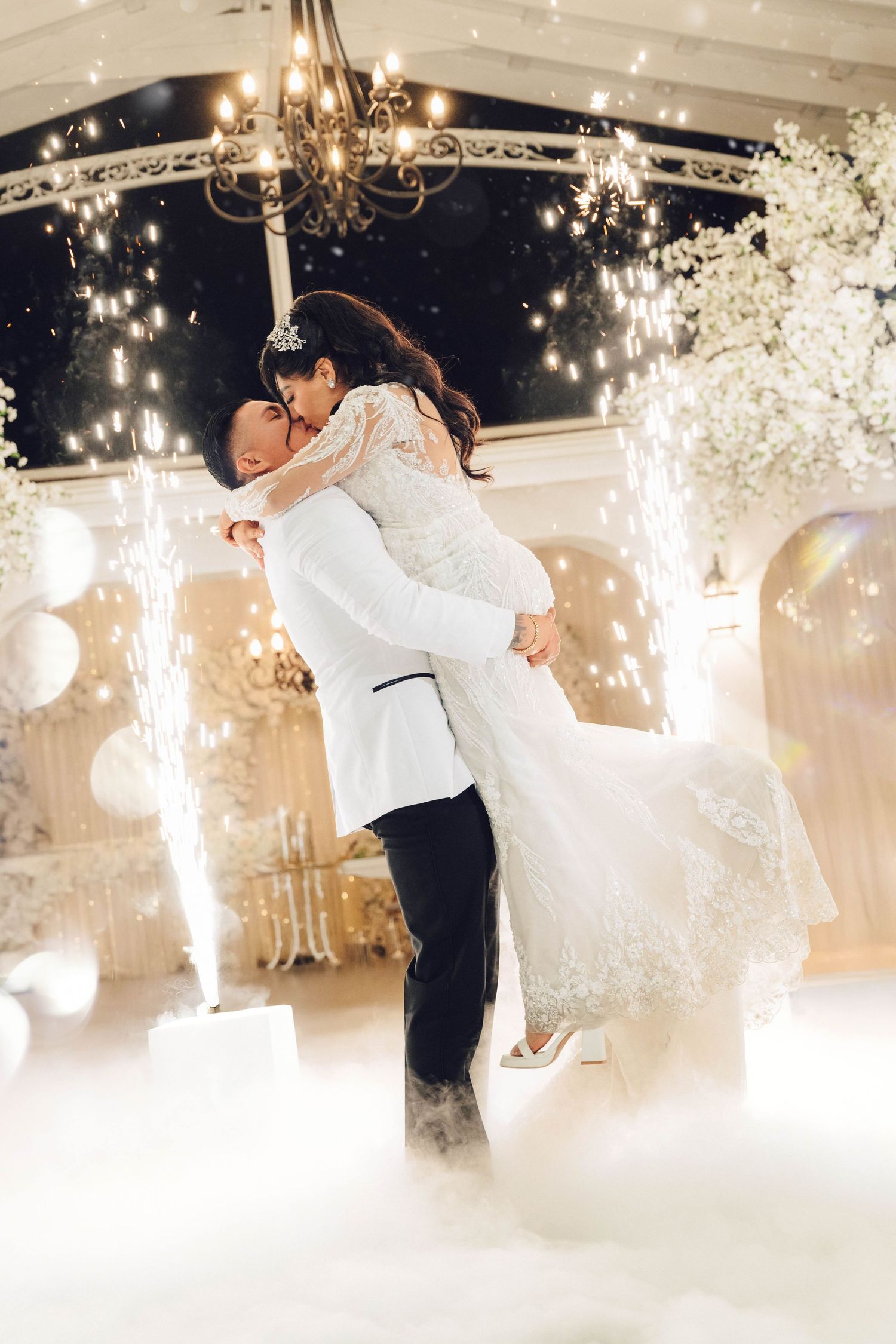 Bride and groom on dance floor with sparklers and white smoke