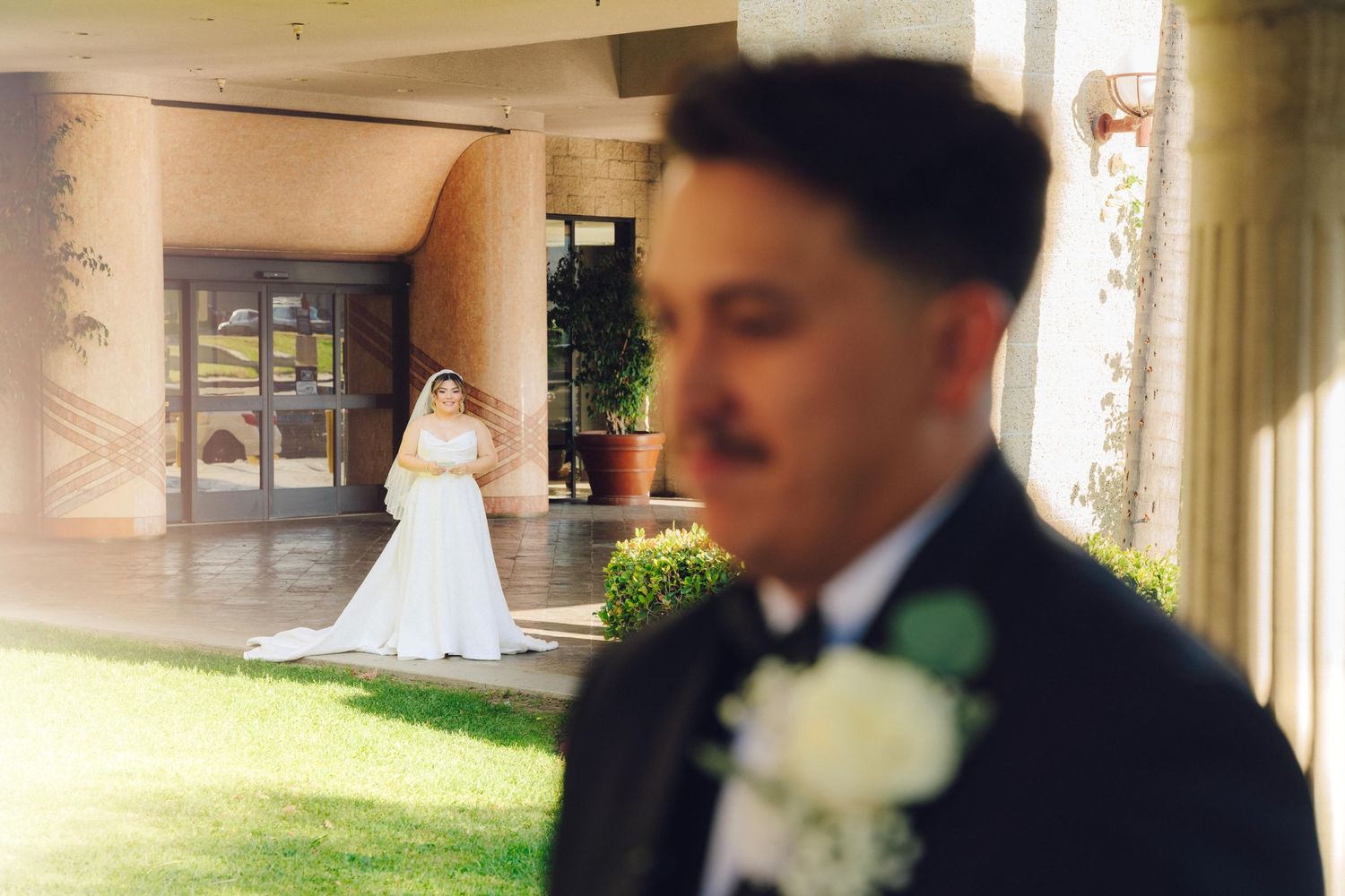 Bride looking at groom from the distance while he waits for her to do the first touch at double tree hotel in rosemead