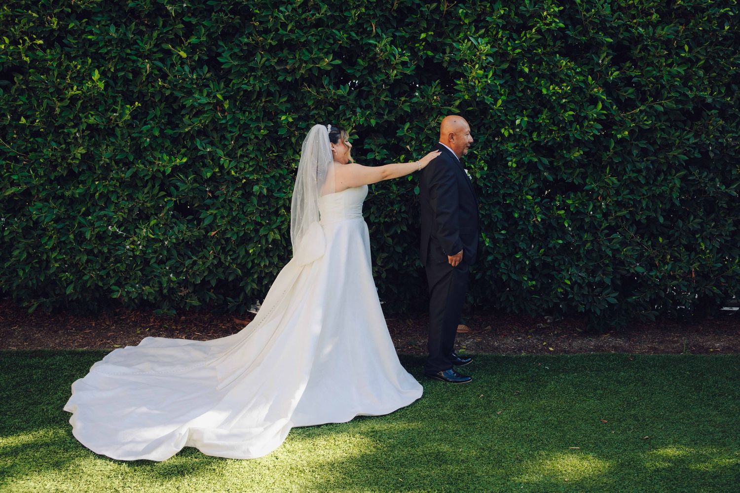 bride doing first look with dad by tapping on his shoulder