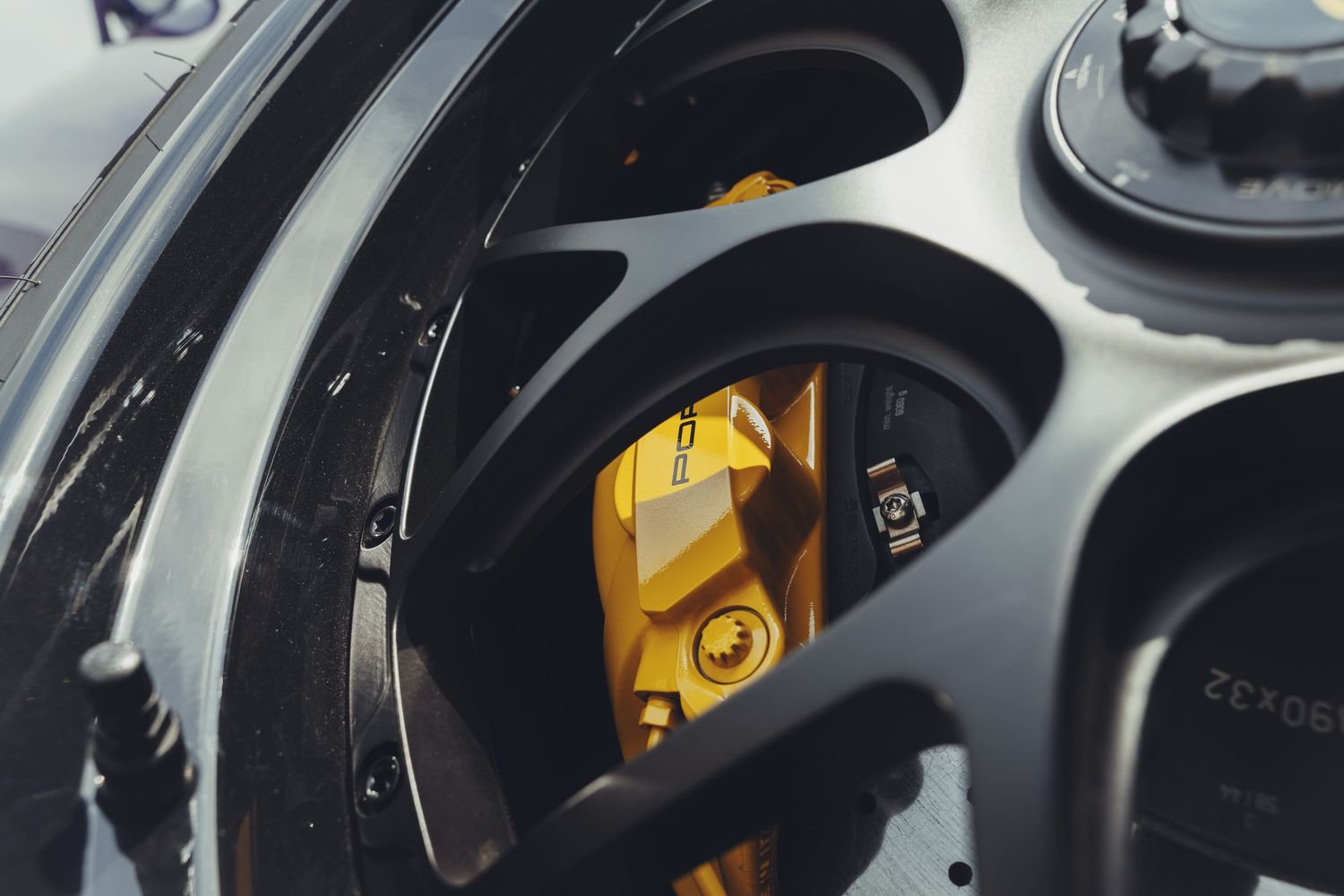 super wide low shot of the porsche wheel with the yellow brake caliper in focus