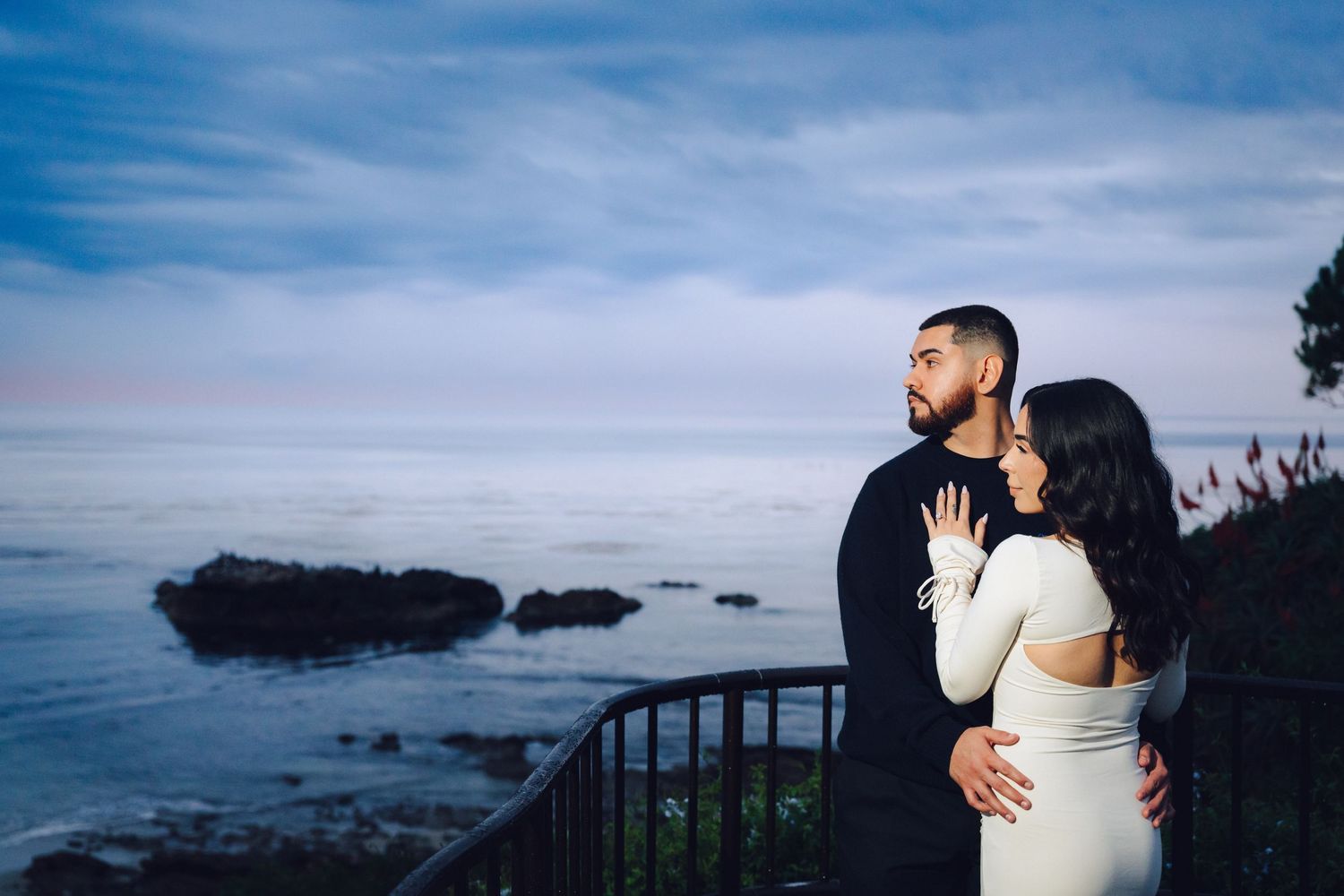 Couple looking out towards the sunset filled with blues in laguna beach