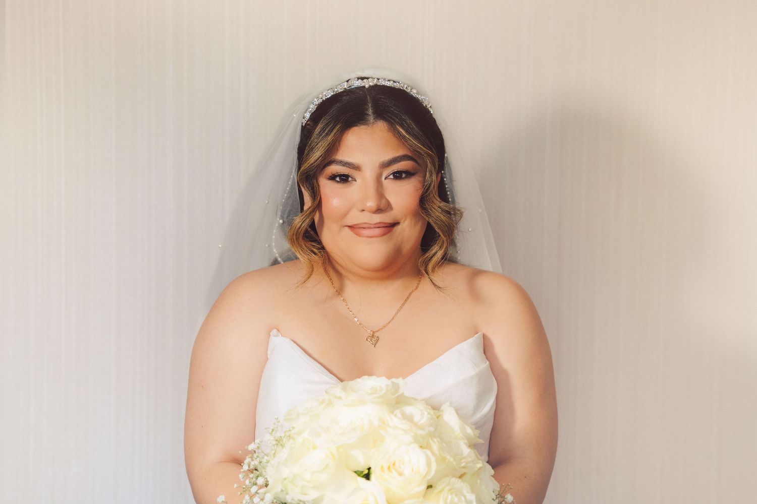 Bride holding her white roses while looking directly at the camera