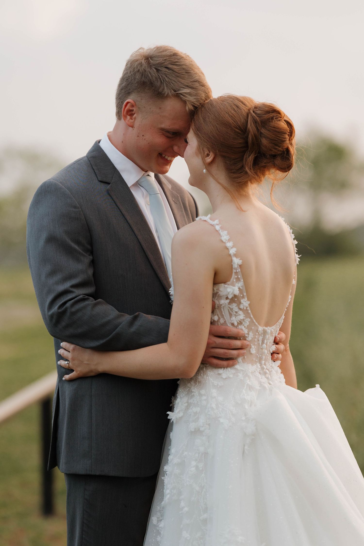 A romantic moment captured between a couple in wedding attire during golden hour outdoors.
