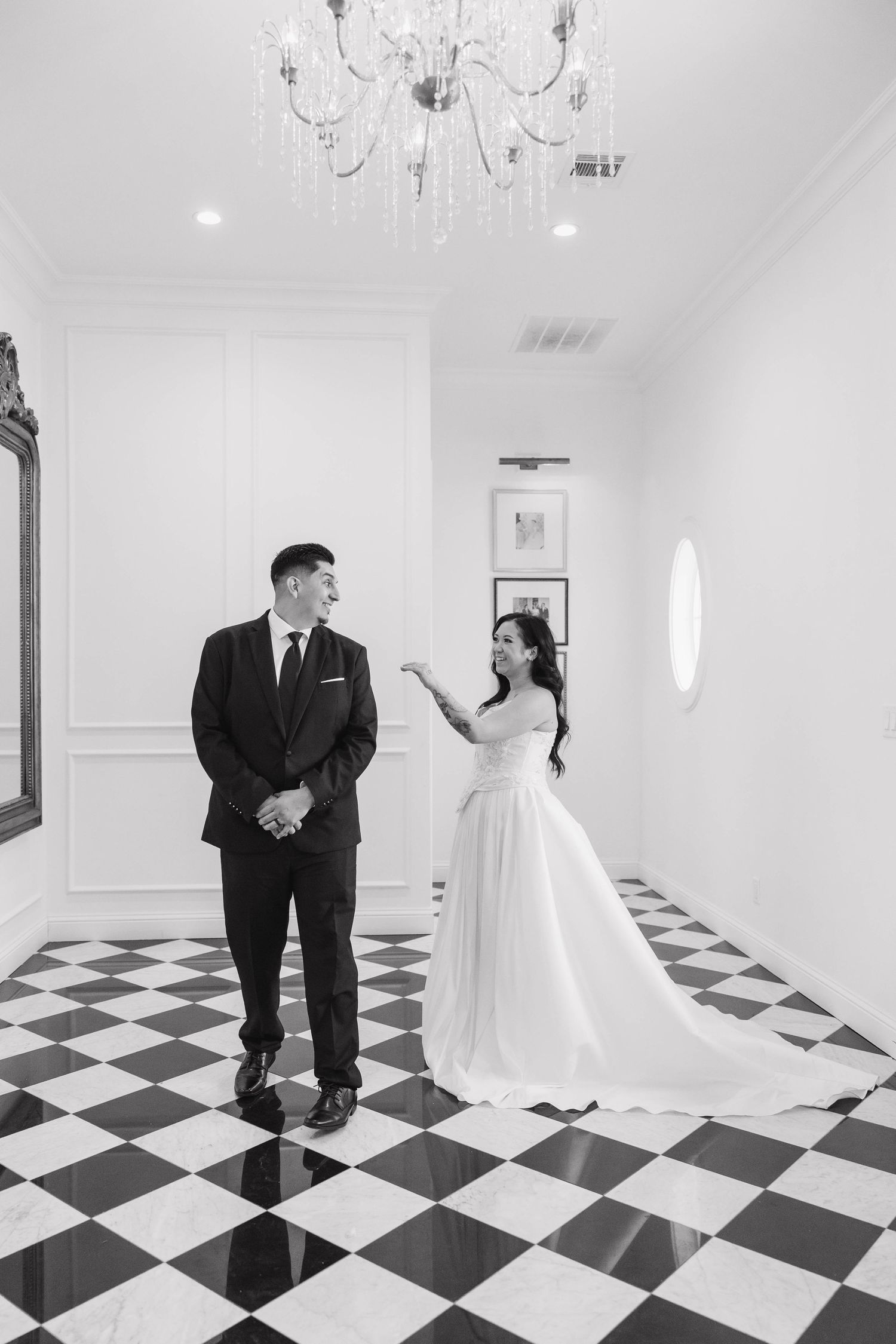 A series of romantic first look photos between a bride and groom in a hallway with black and white checkered floors.