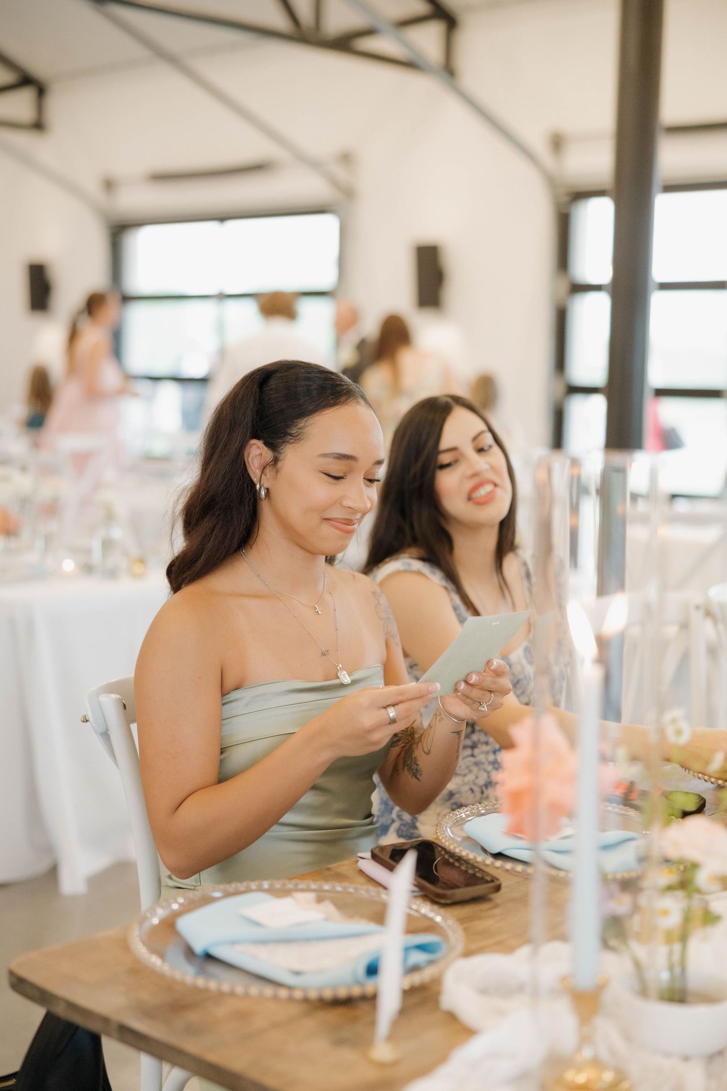 Wedding guests enjoying a lively dinner reception at tables decorated with floral centerpieces.