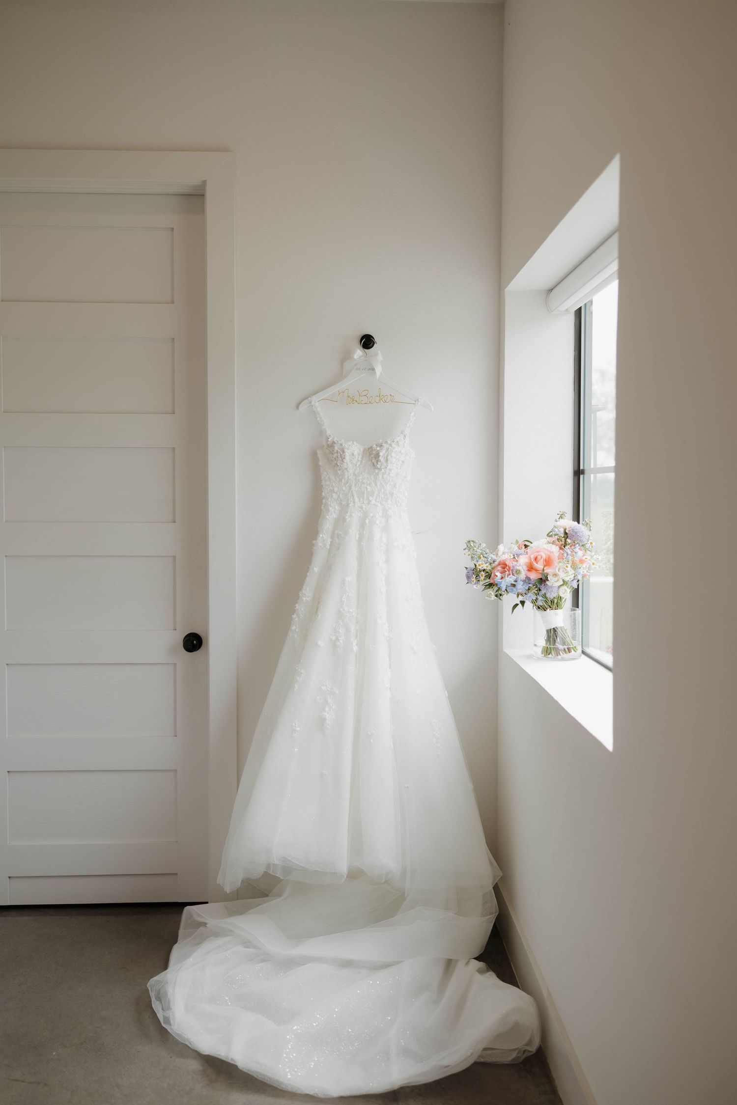 A sequence of five photos showing a white lace wedding dress hanging against light colored walls near a small window.