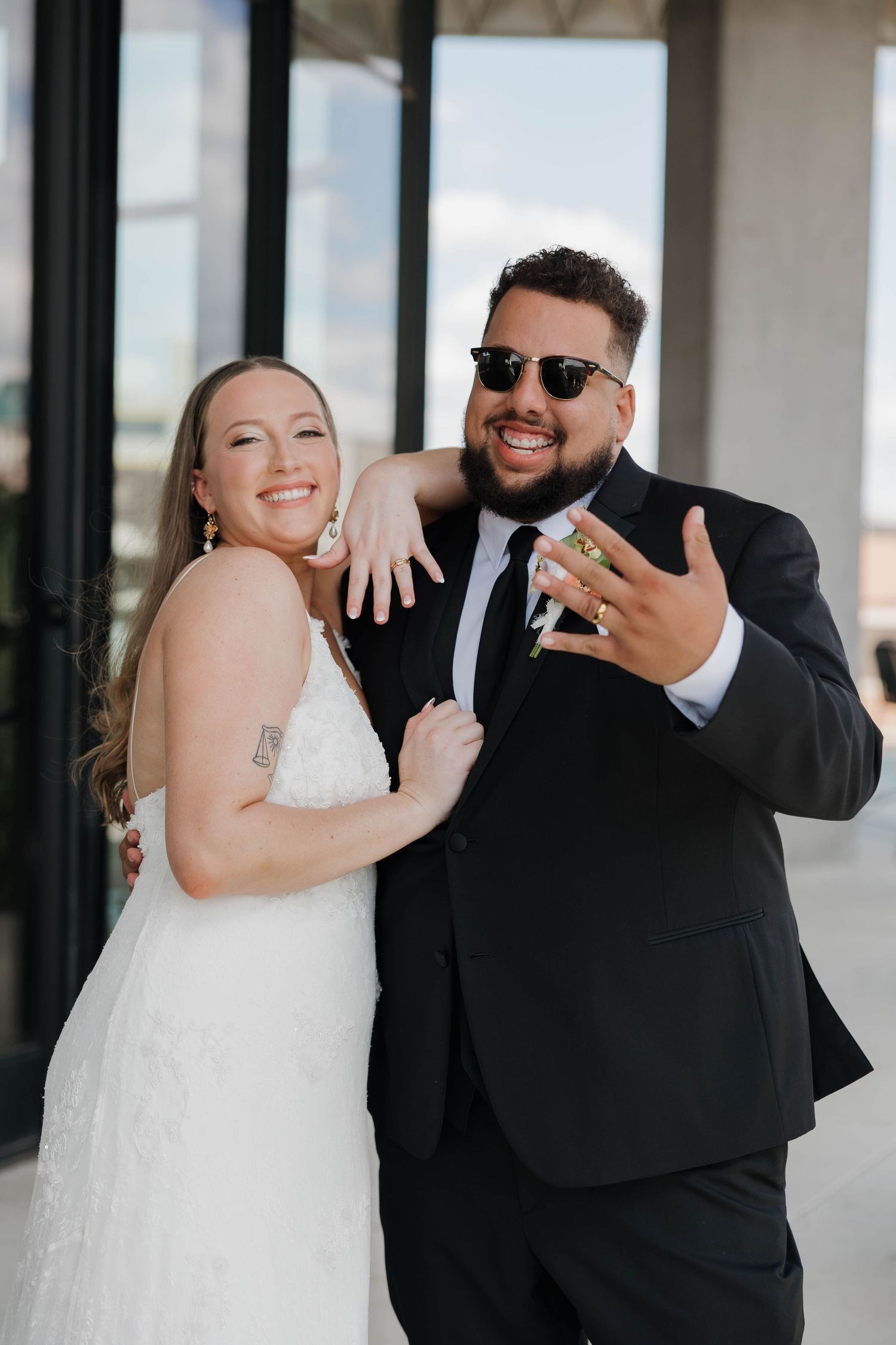 Wedding couple poses joyfully together during outdoor celebration.