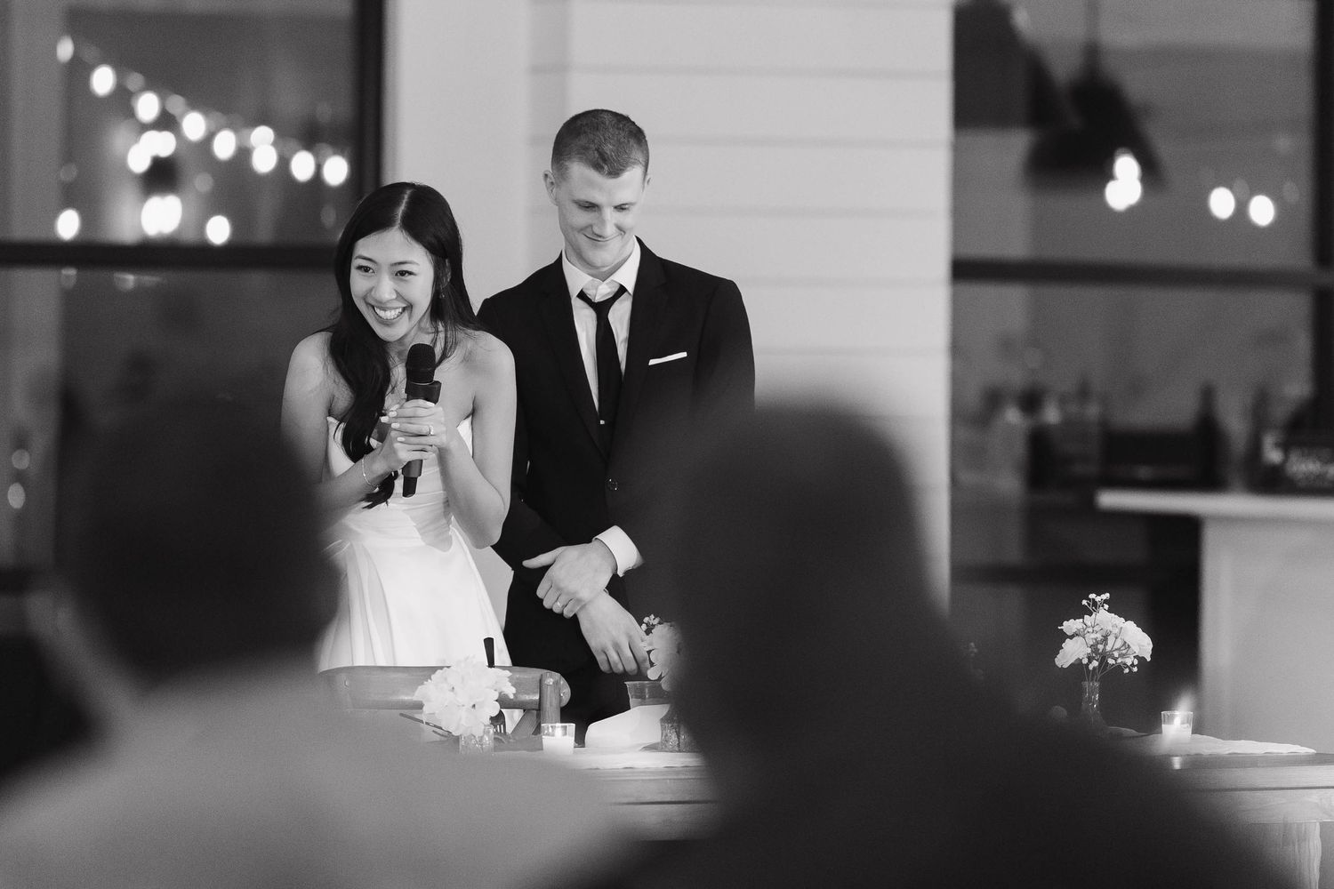 A sequence of black and white candid shots capturing romantic moments at an elegant indoor celebration.
