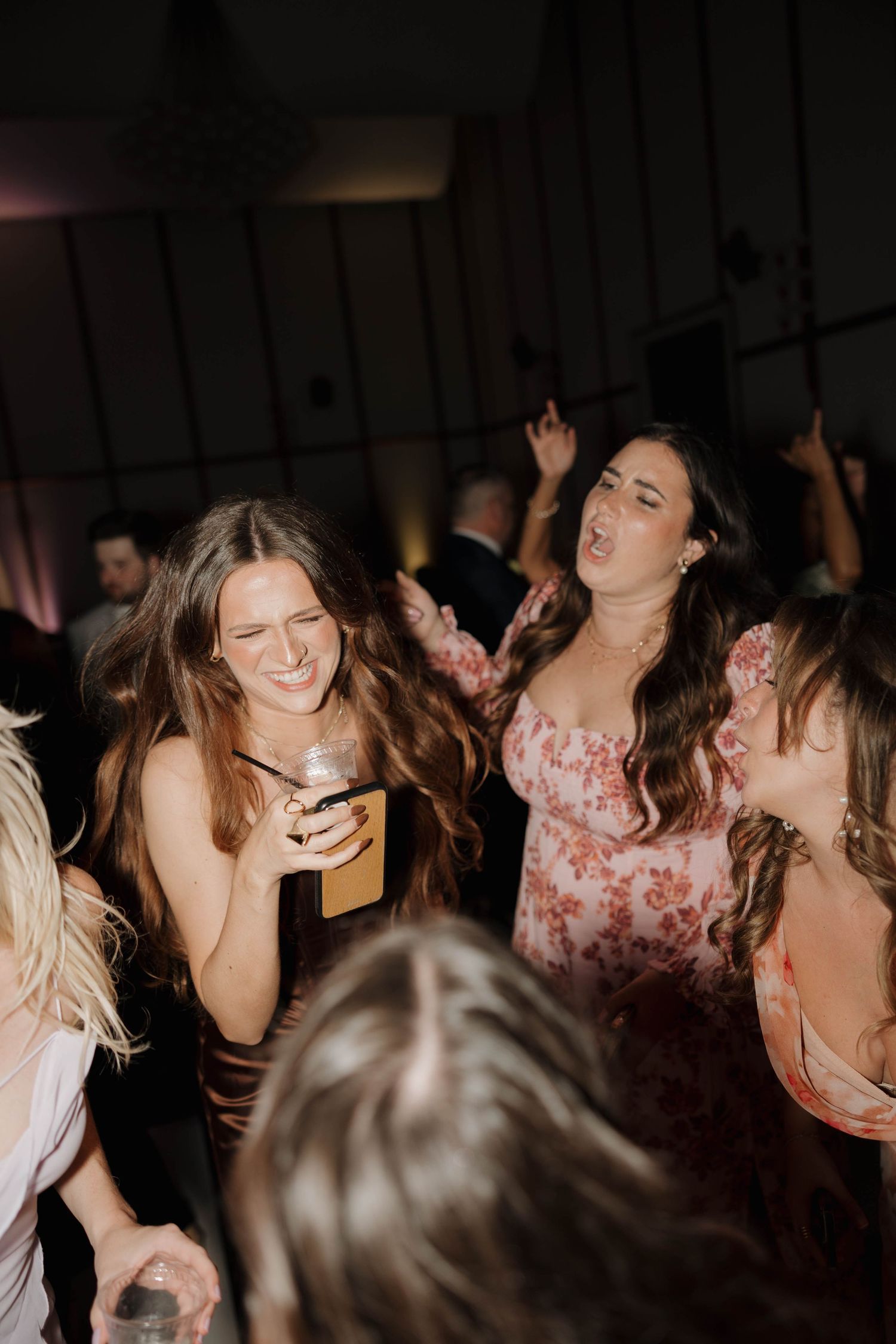 People dancing and celebrating at a dimly lit party venue.