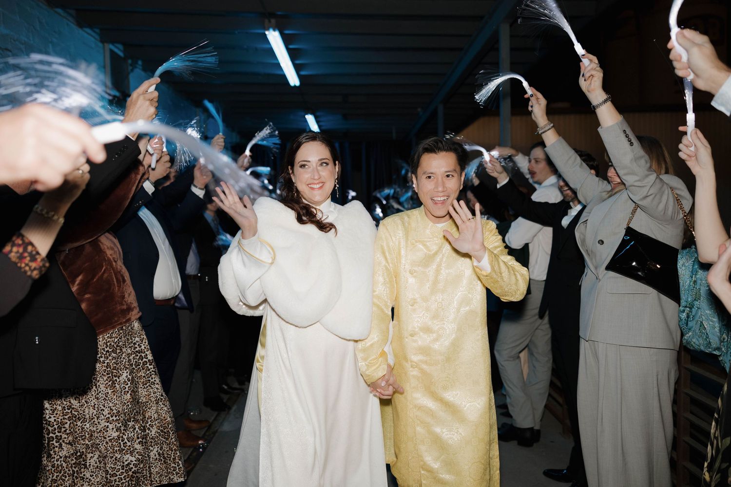A crowd of wedding guests dancing together on the dance floor during an evening celebration event.