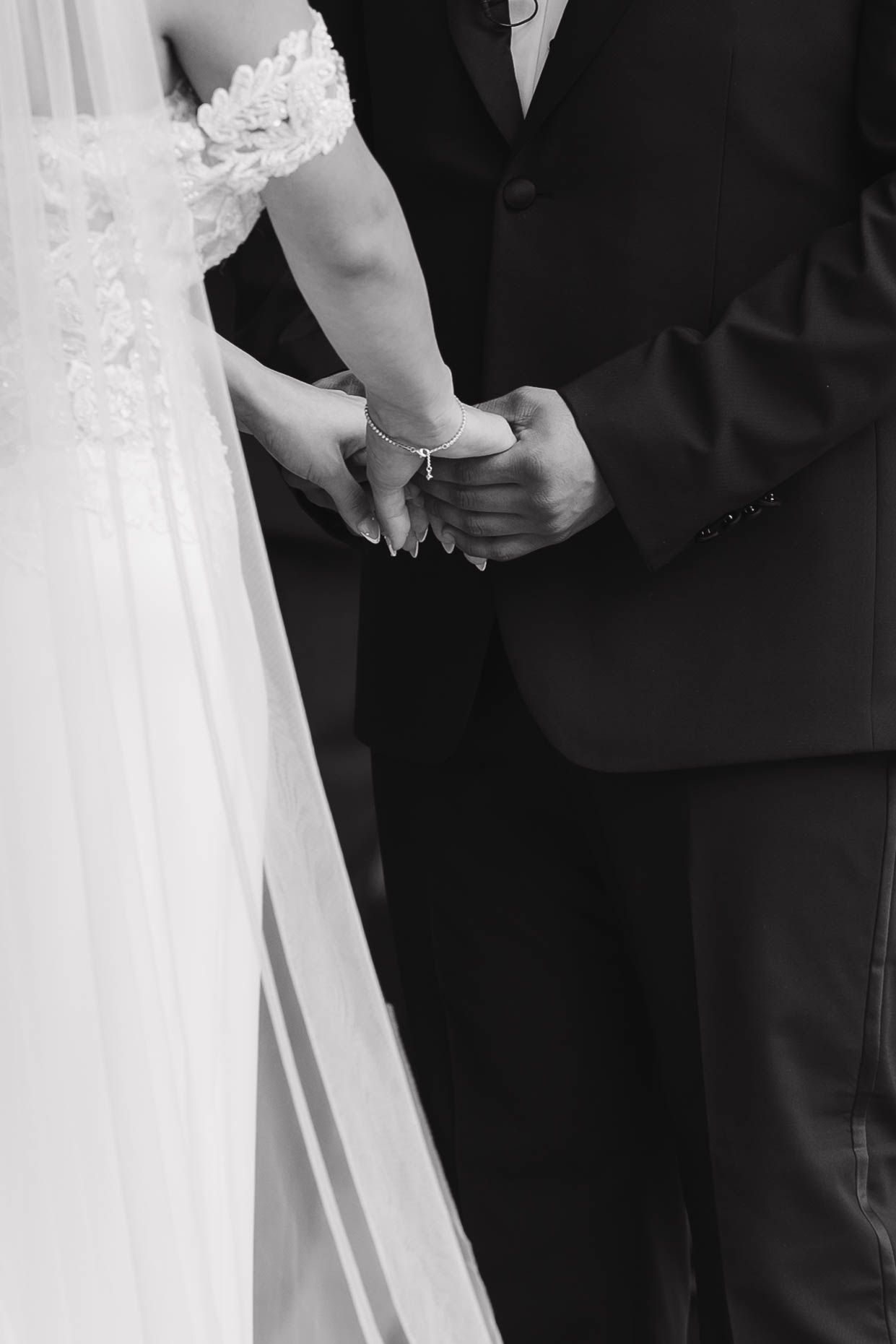 A wedding couple shares an intimate moment holding each other in black and white photography.