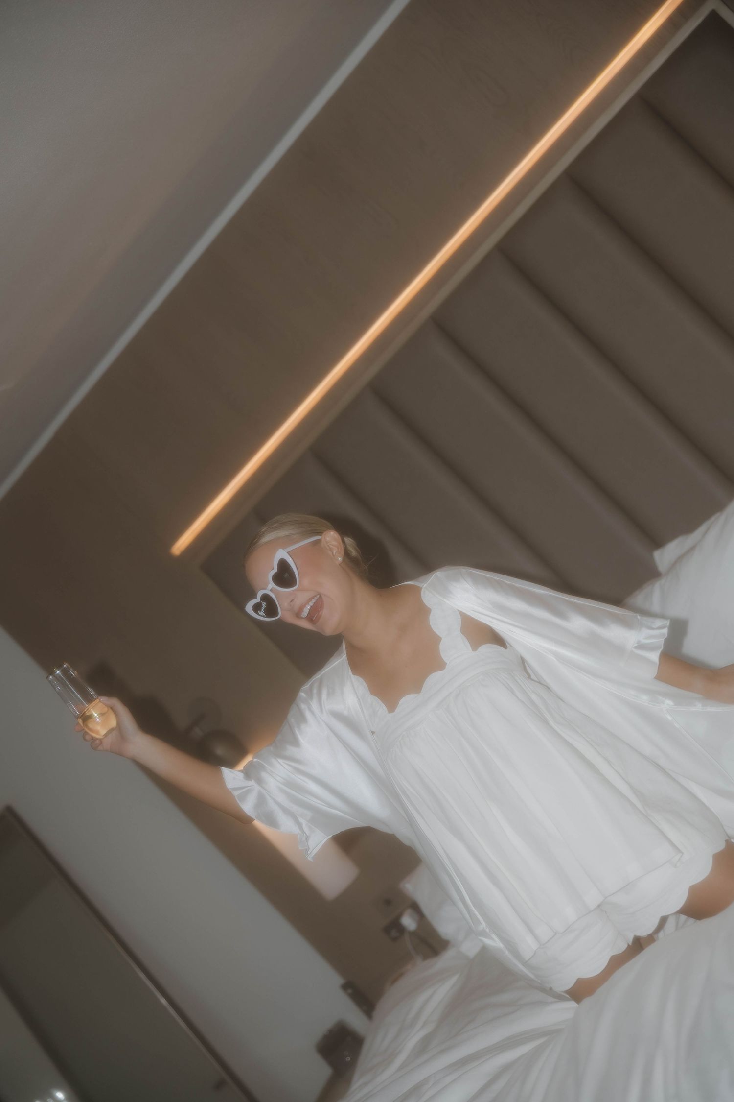 A bride in a flowing white dress twirls gracefully in a series of artistic wedding photos.