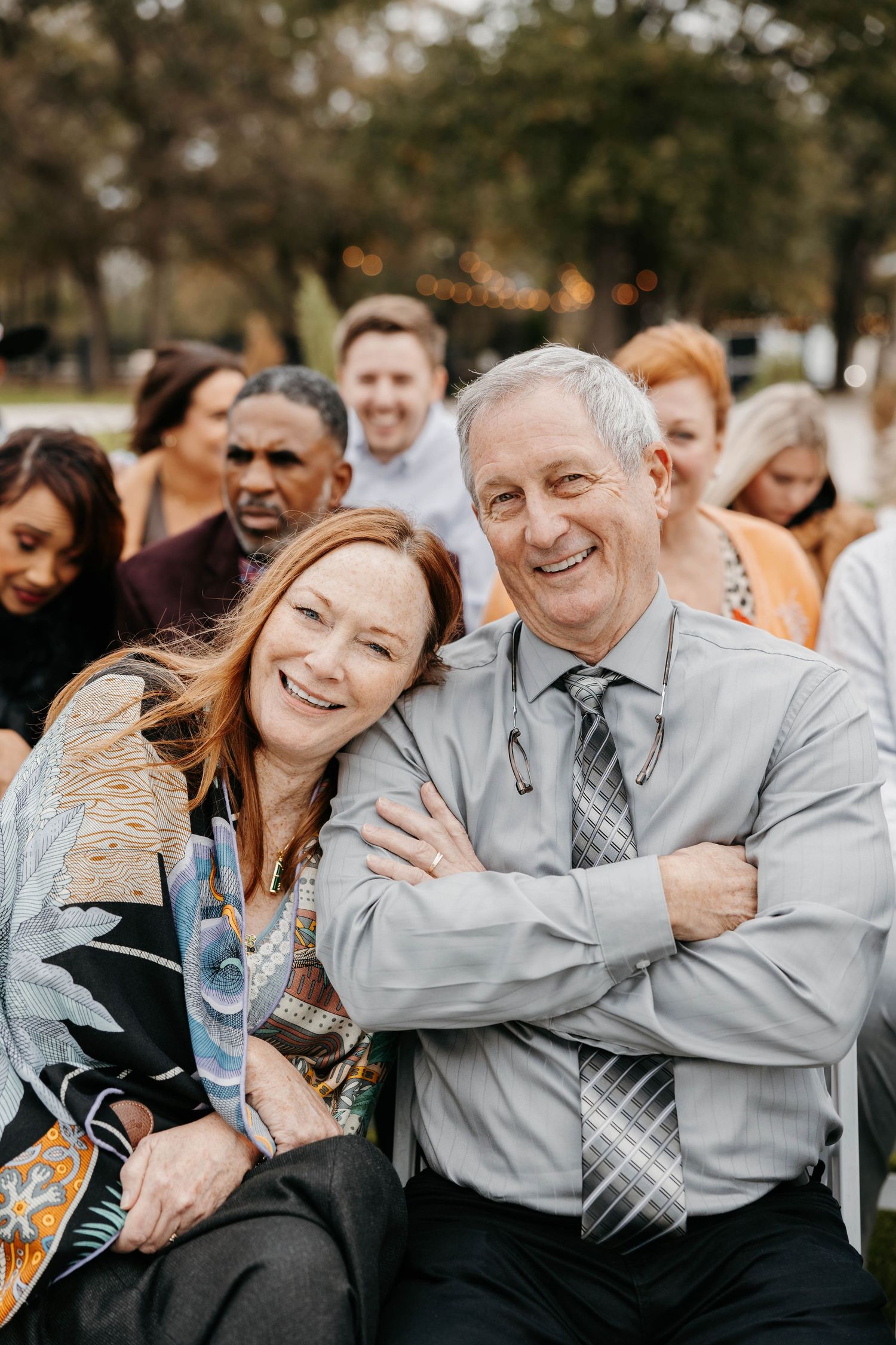 A candid sequence of joyful group photos showing people in matching gray outfits sharing genuine laughter and embraces outdoors.