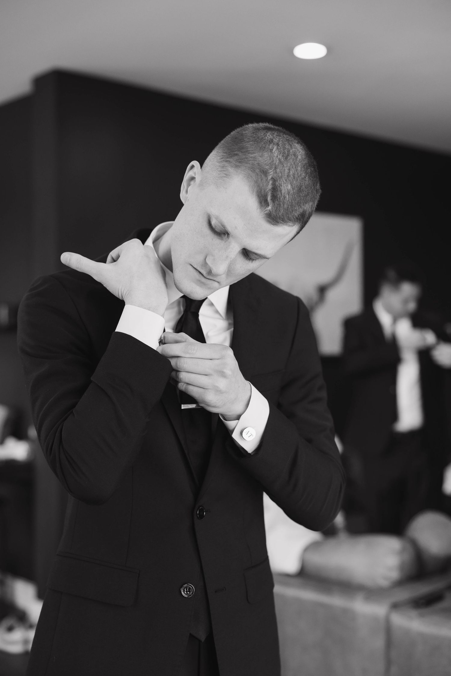 Black and white panorama showing silhouettes of a person making expressive hand gestures in formal attire.