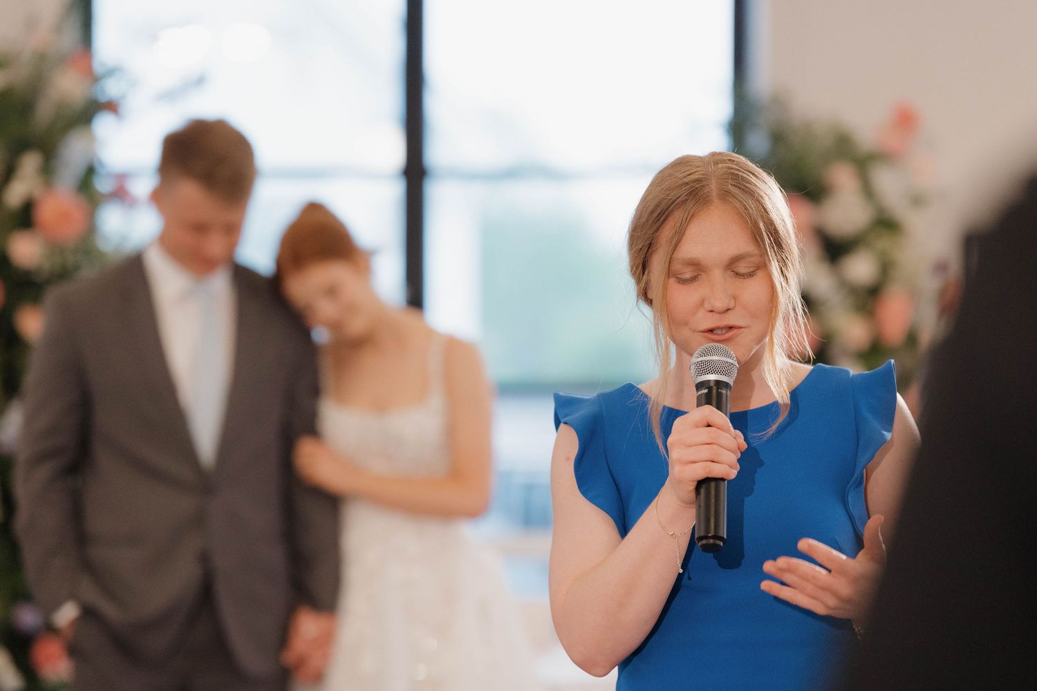 Wedding guests react emotionally during speeches at an elegant indoor reception venue.