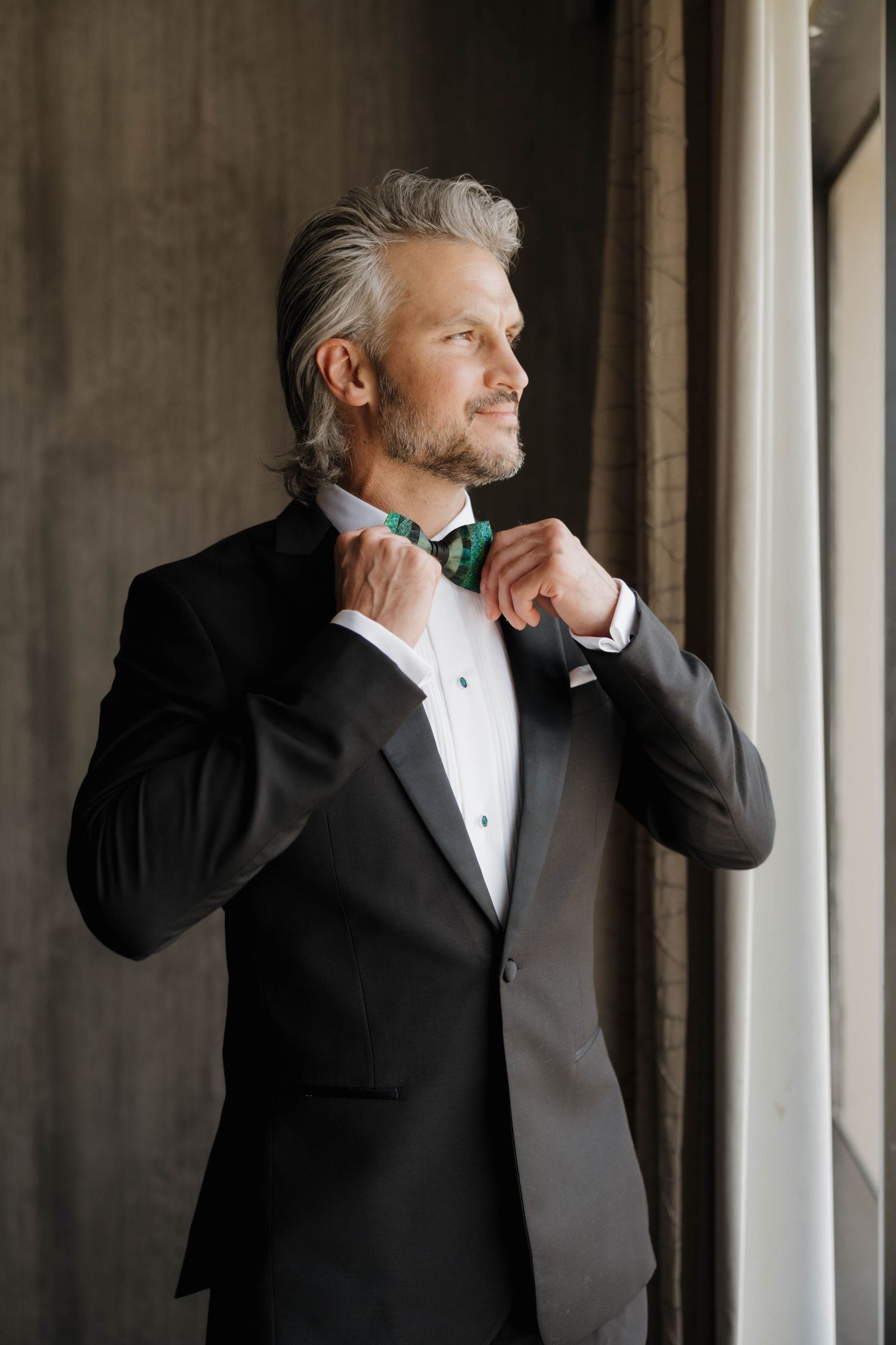 Series of photos showing a man in a black tuxedo adjusting his bowtie while looking out a window.