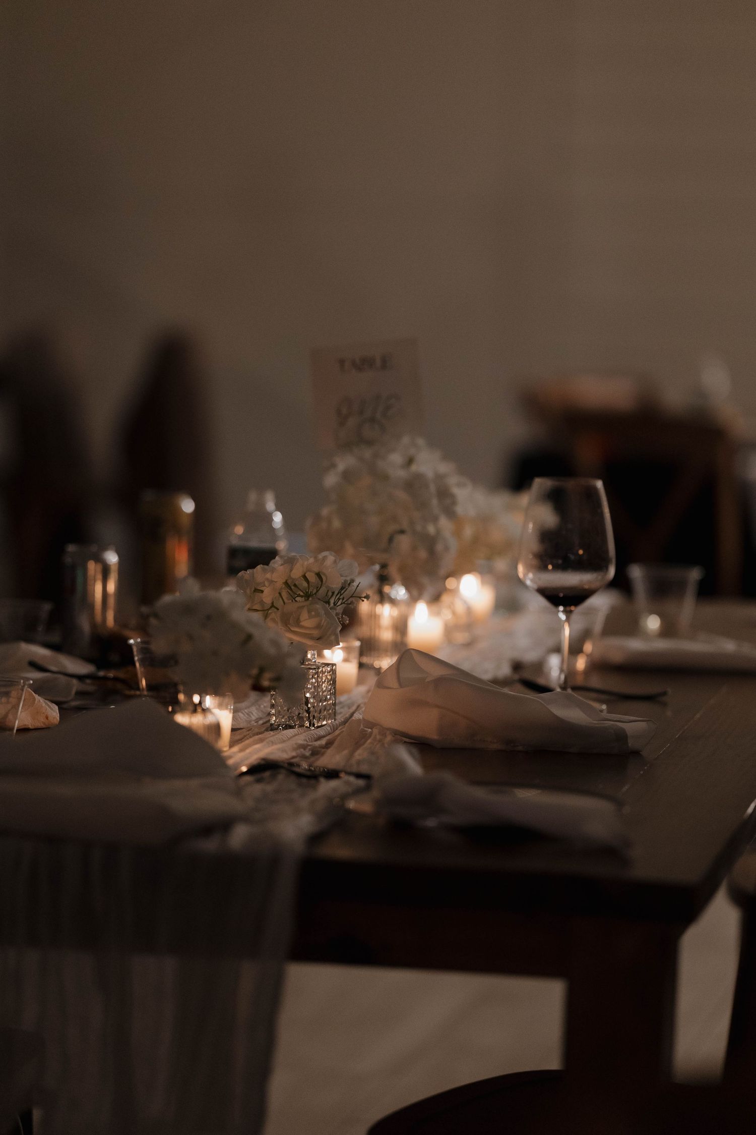 Wedding reception tables decorated with elegant candles and soft ambient lighting creating a romantic atmosphere.