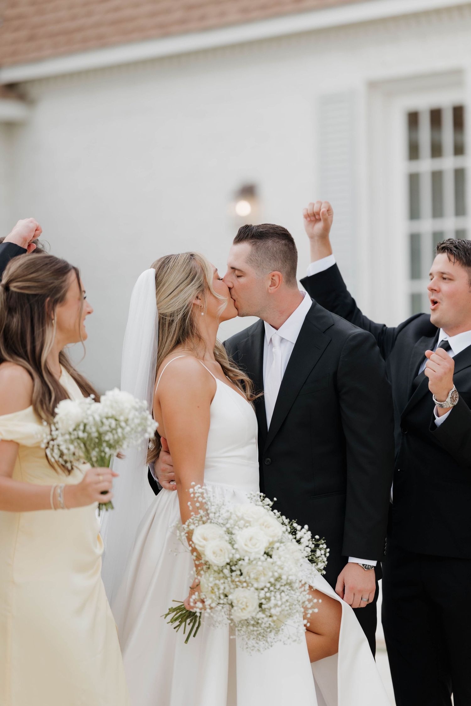 Four sequential images show a couple in wedding attire dancing and celebrating with playful gestures at an outdoor venue.