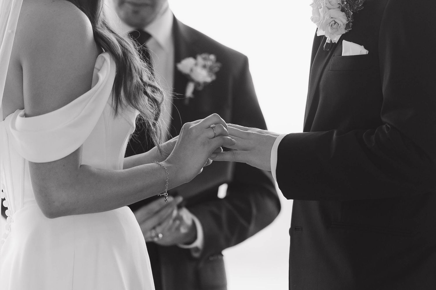 Bride and groom walk down aisle at traditional wedding ceremony surrounded by wedding party in formal attire.