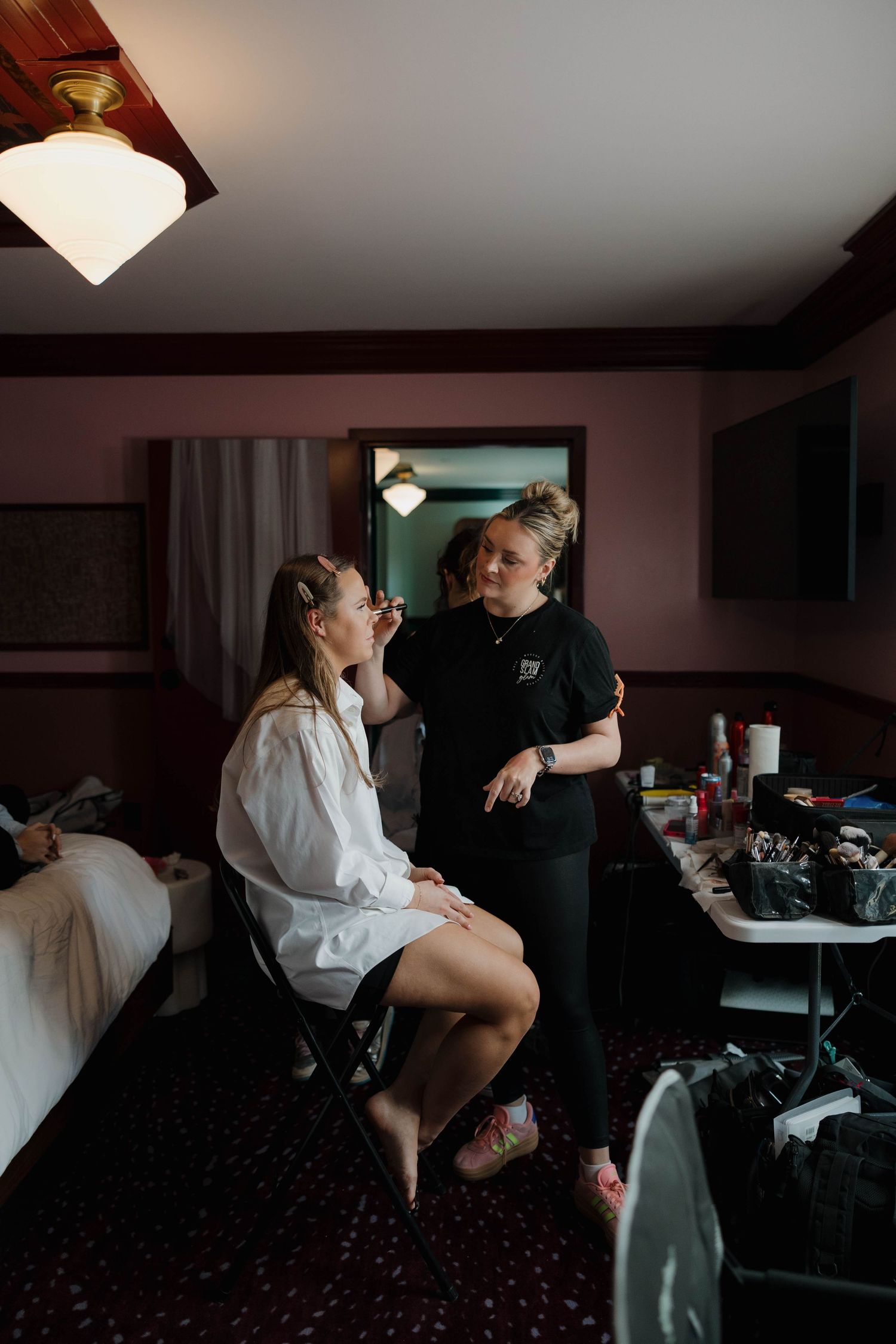 A couple shares an intimate moment in a dimly lit room during wedding preparations.