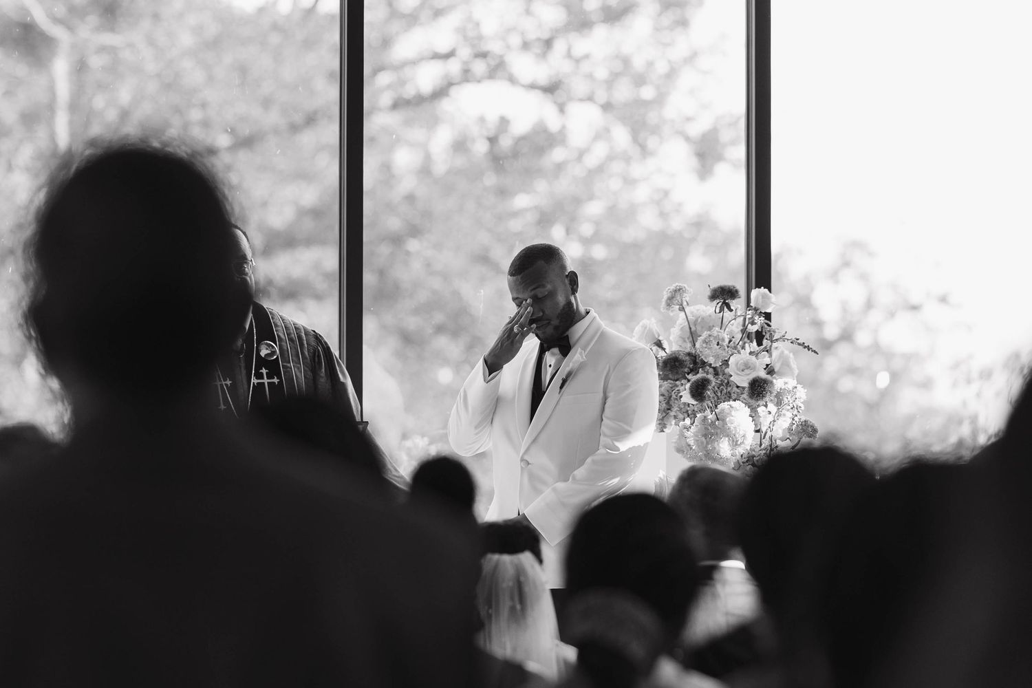 A silhouetted group of people are seen in conversation against a bright white background.