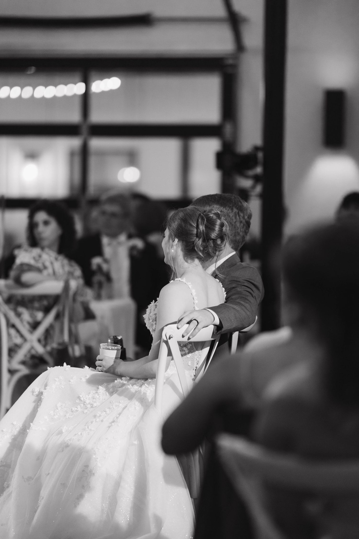 Black and white photo sequence of a couple dancing their first dance at a wedding reception under dimmed lights.