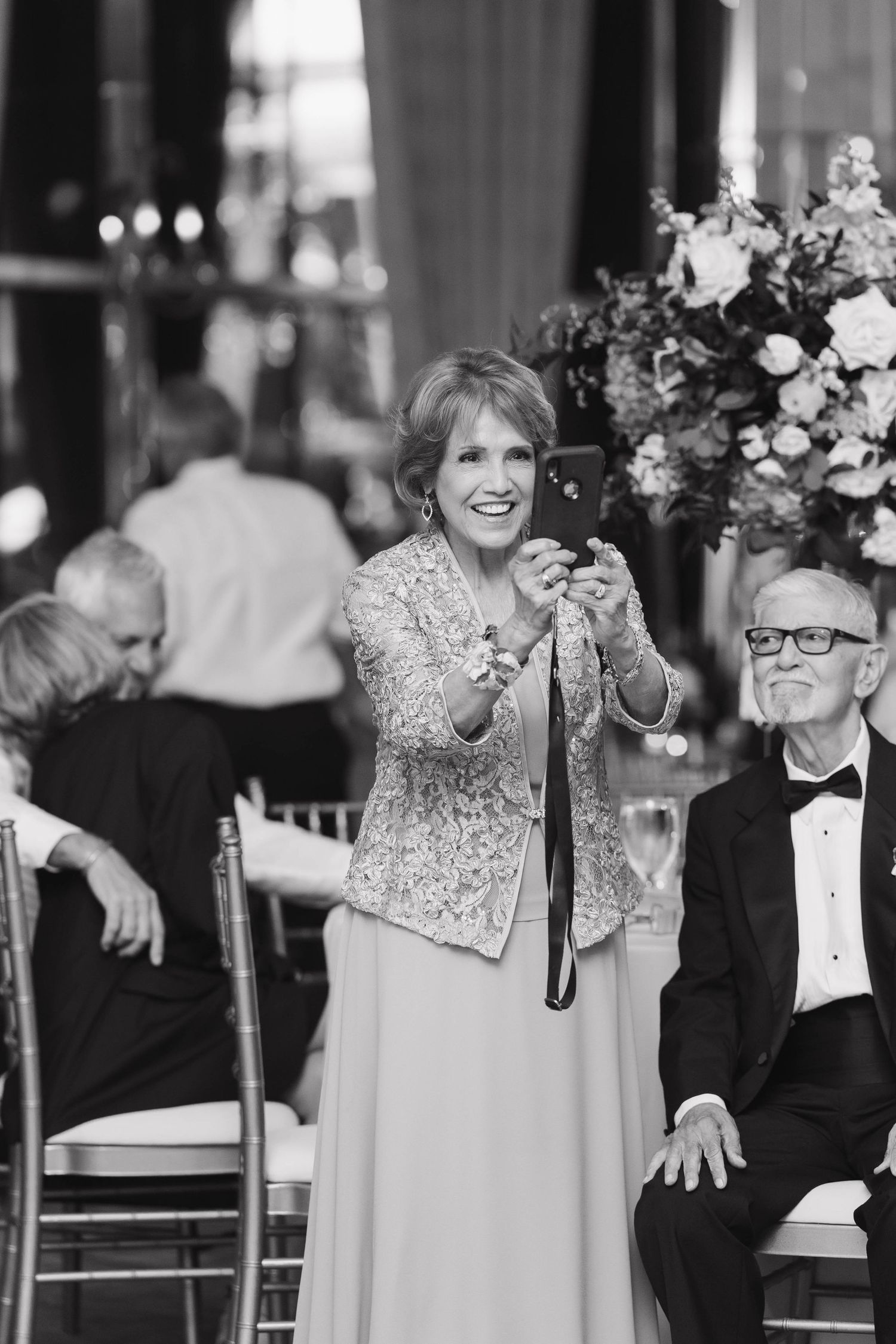 Reception celebration featuring guests sharing joyful laughter and smiles at an elegant formal event.