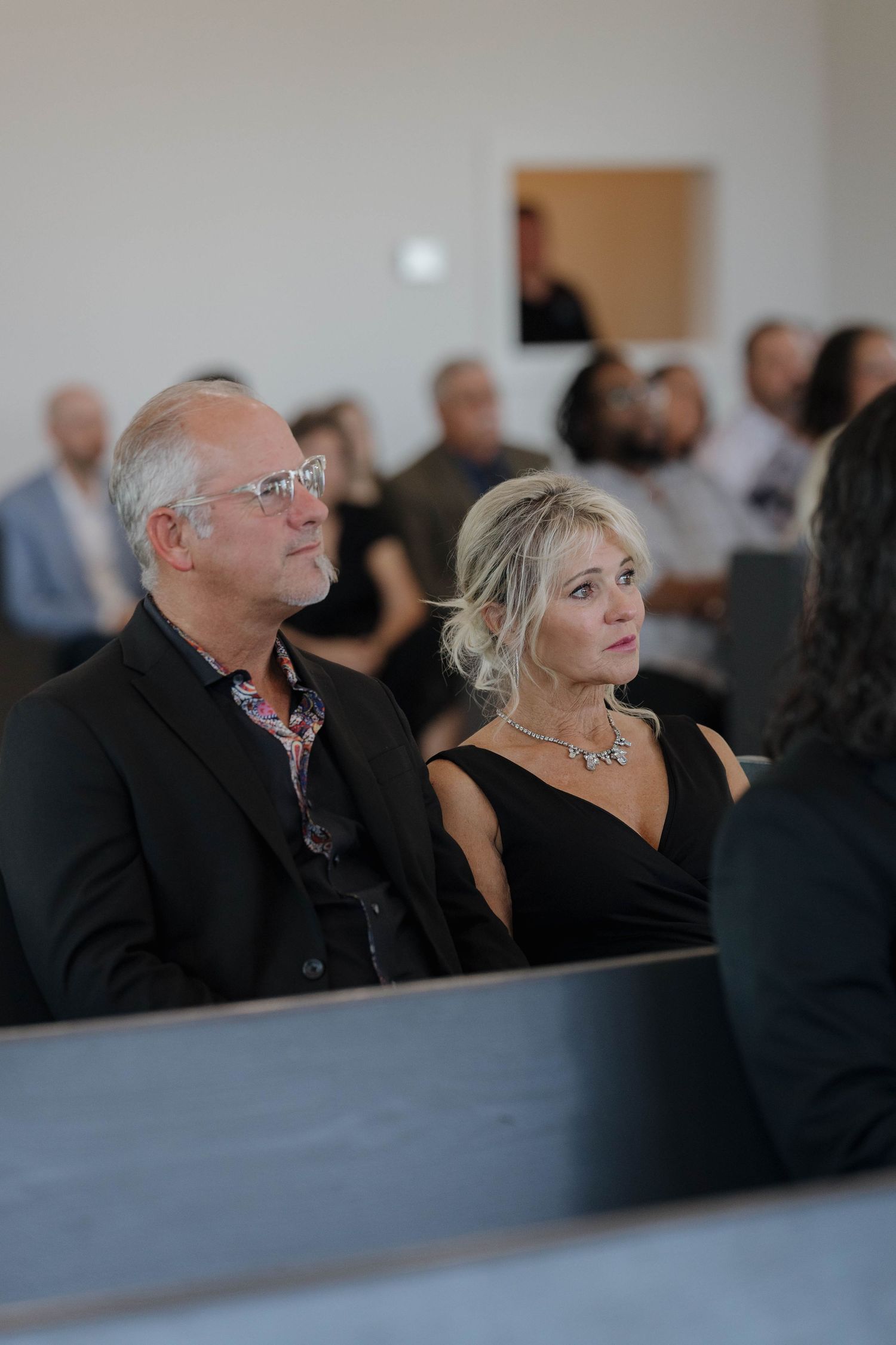 People sitting in church pews during what appears to be a formal event or service.
