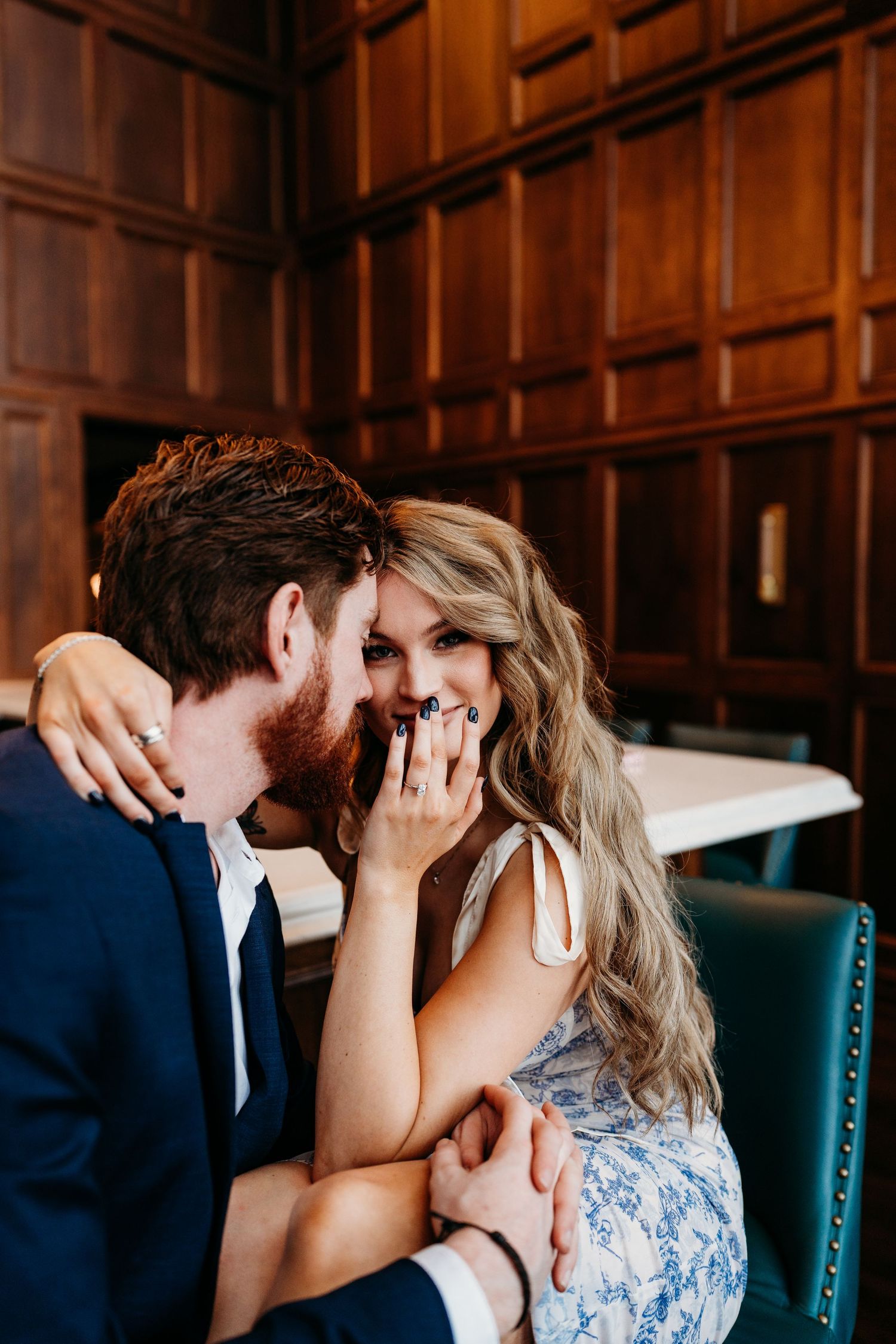 A romantic couple shares an intimate moment in a wood-paneled room with dramatic lighting.
