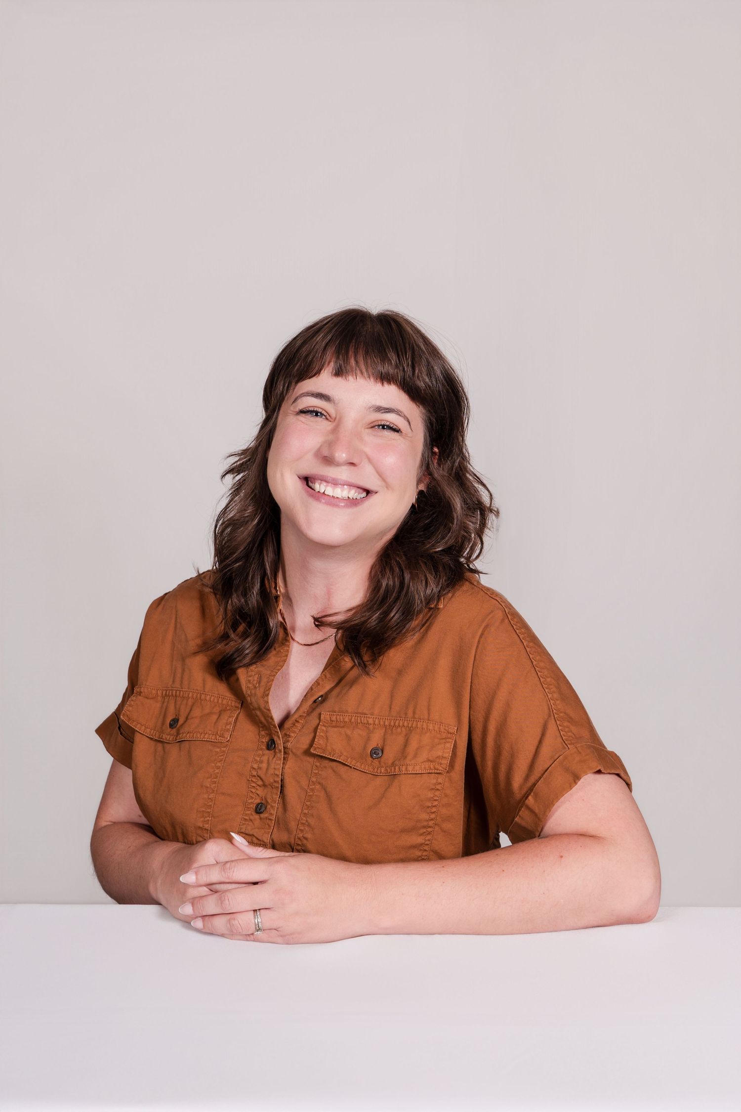 A series of four photos showing someone in a brown button-up shirt laying on a white surface with joyful expressions.