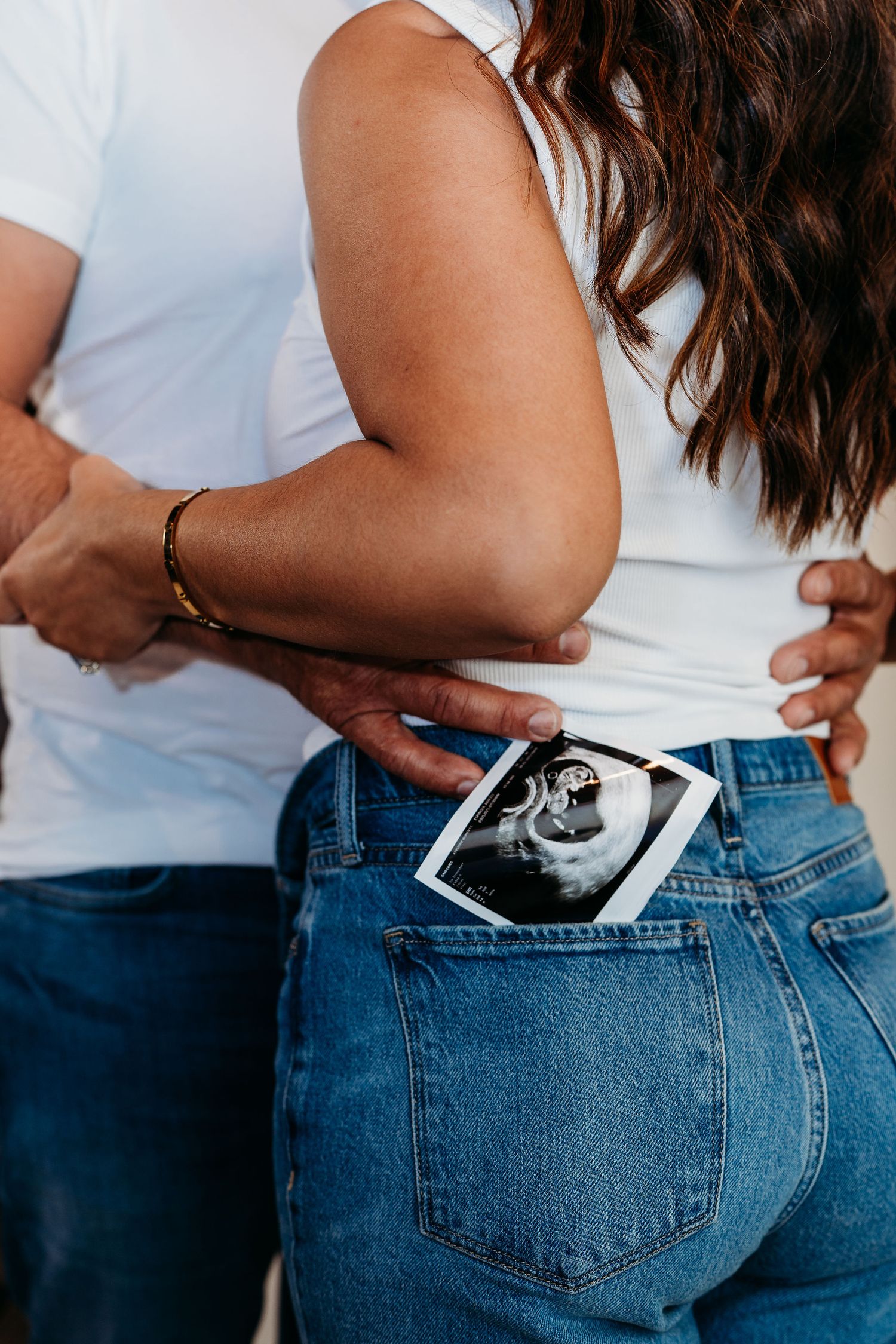 Close-up of ultrasound photo tucked into back pocket of blue jeans.