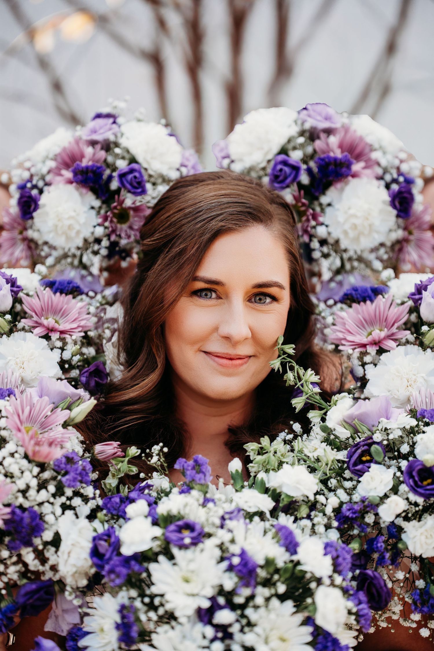 A beautiful floral arrangement featuring white hydrangeas, purple delphiniums, and pink gerbera daisies creates a romantic scene.