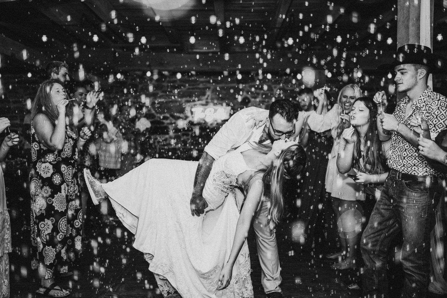 Black and white photo of dance floor celebration with falling sparkles and confetti.