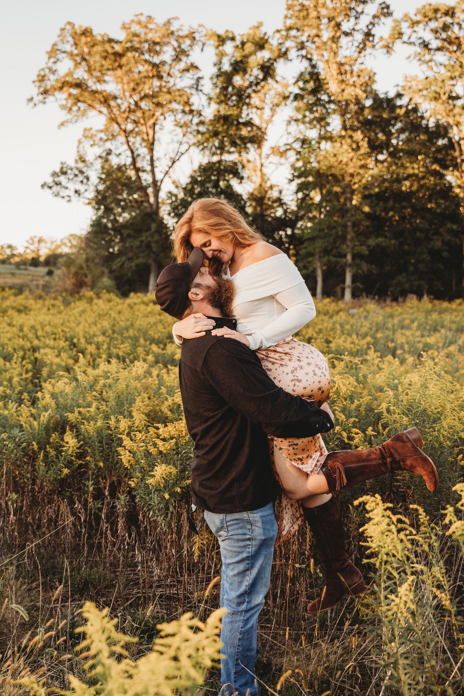 A romantic moment captured between a couple in a golden field at sunset.