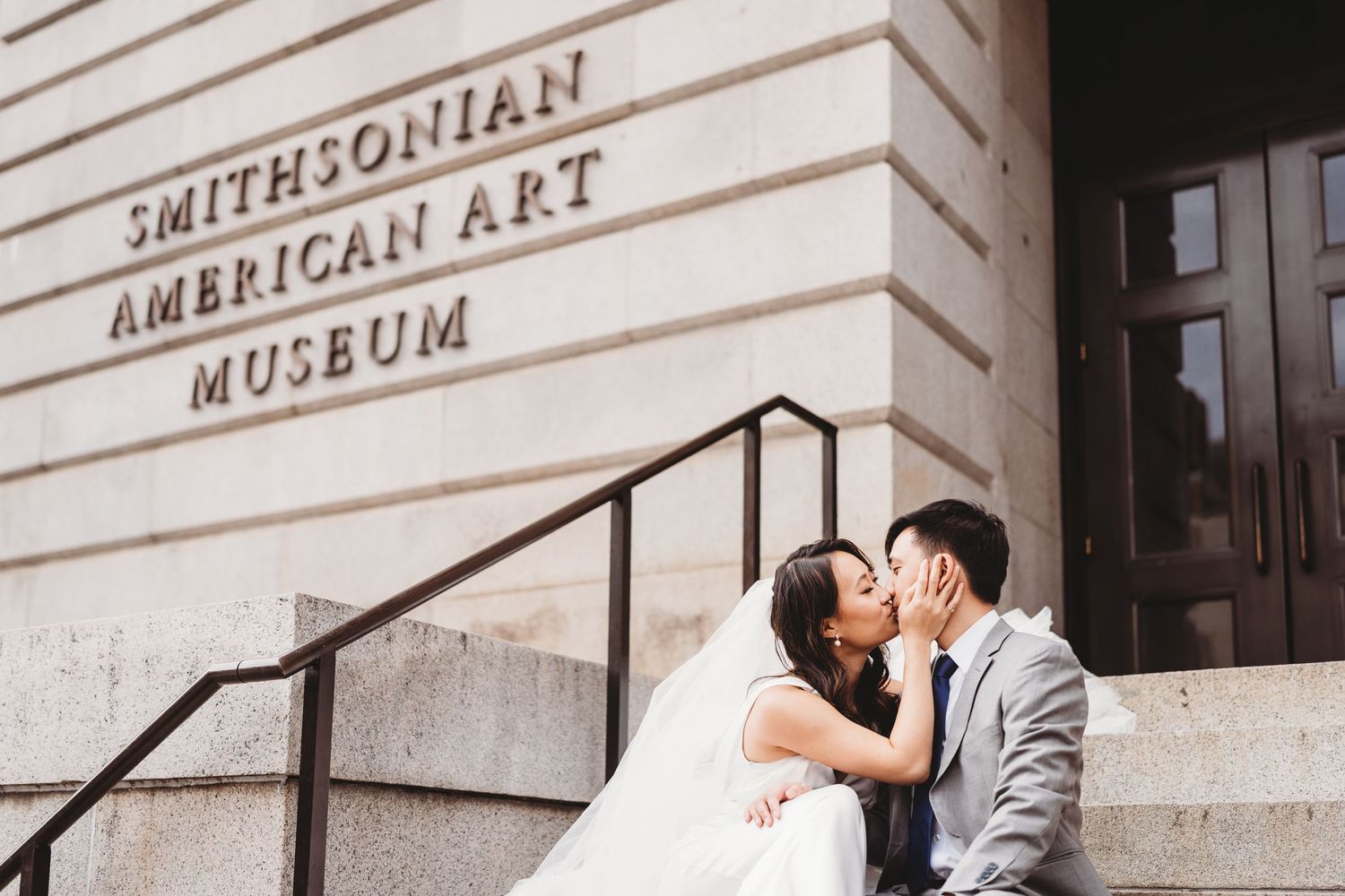 A couple shares a romantic moment on the steps of the Smithsonian American Art Museum.