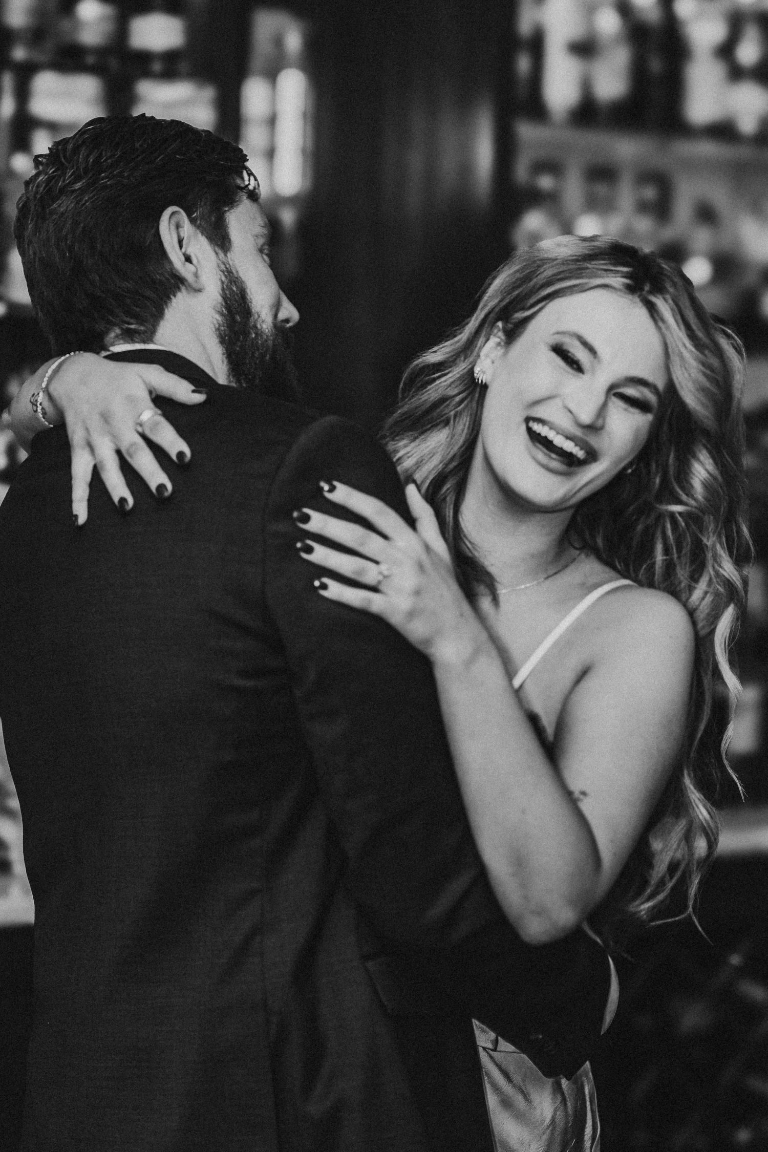 A black and white photo series showing a couple embracing and laughing together in an intimate moment.