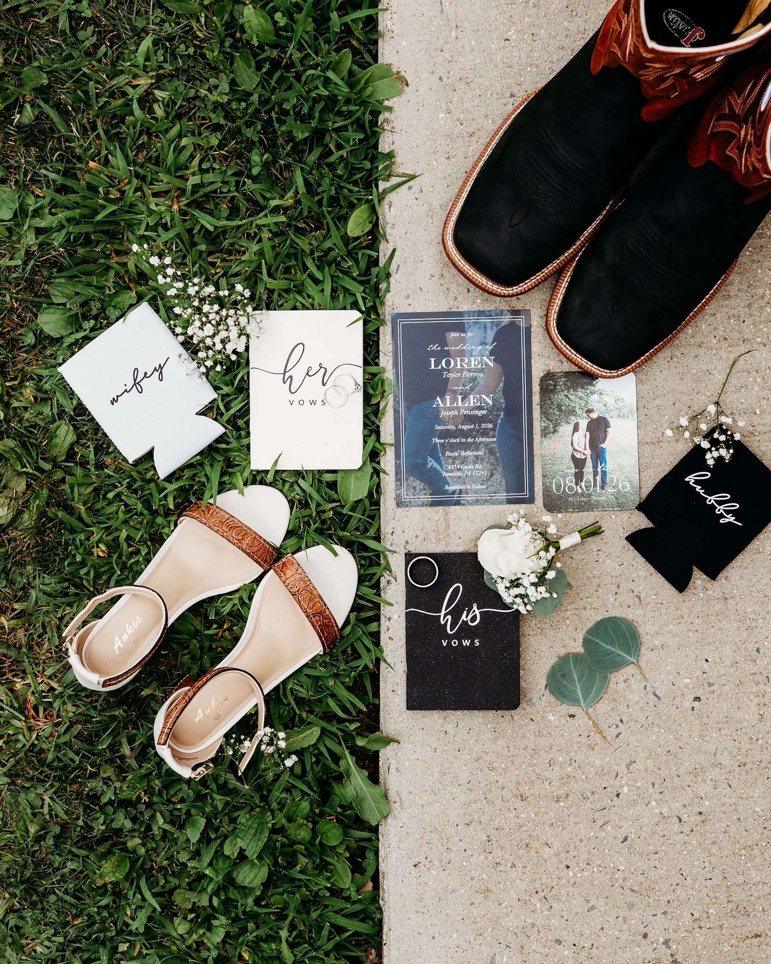 Wedding flat lay featuring bridal shoes, groom boots, vow books, invitations, boutonniere, and accessories on grass and pavement.