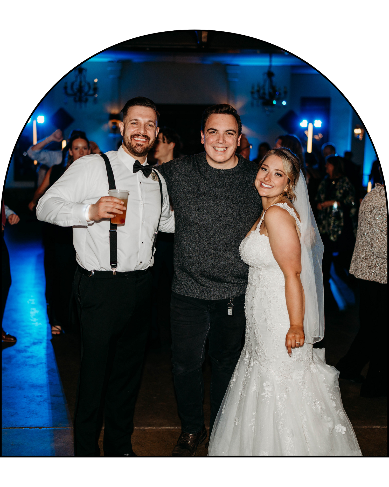 Reception celebration with guests in formal attire under blue mood lighting.