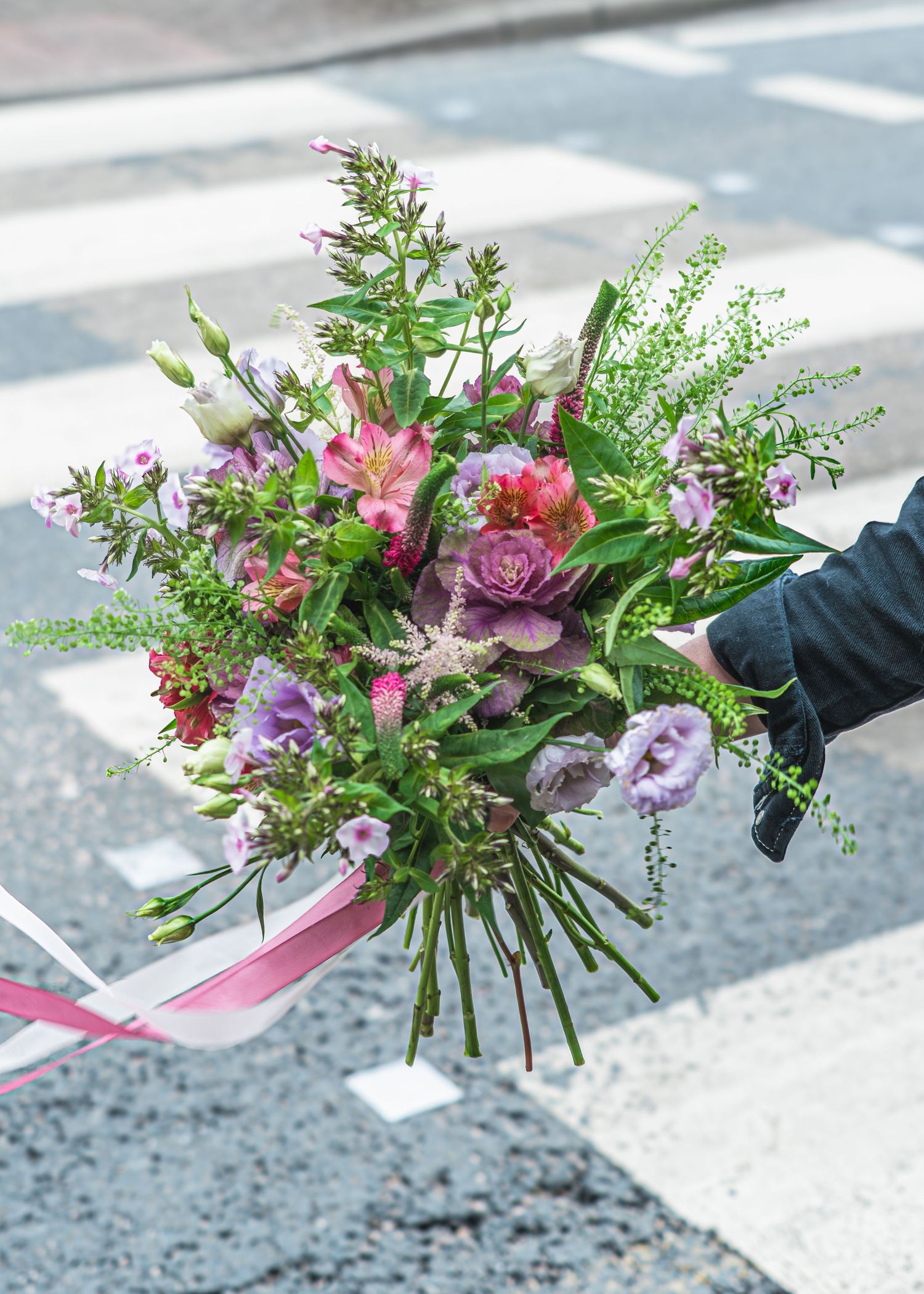 A florist arranges a vibrant bouquet with pink roses, purple flowers and green foliage in a dynamic sequence of photos.