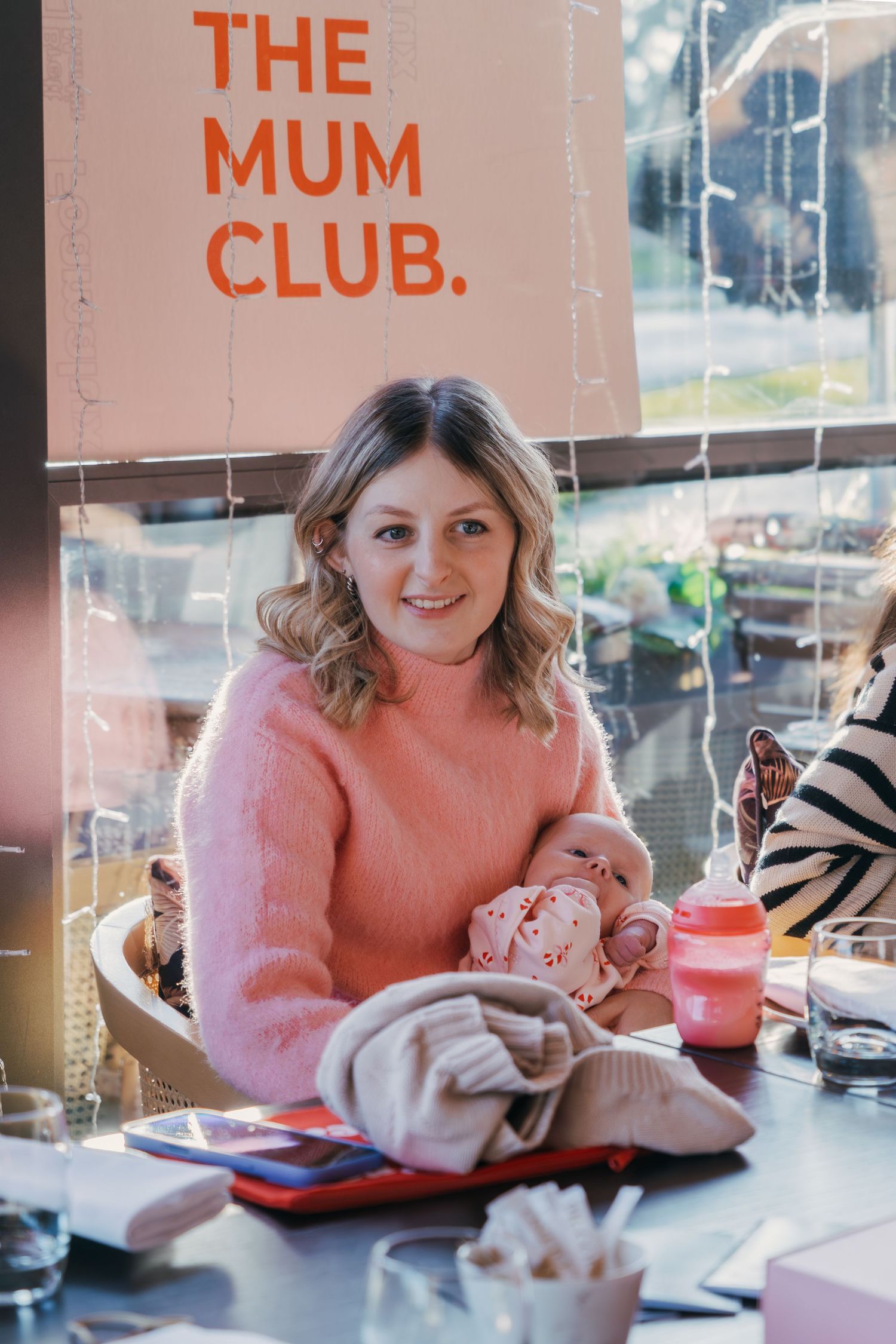 Cozy cafe interior with pink walls and comfortable seating arrangements.